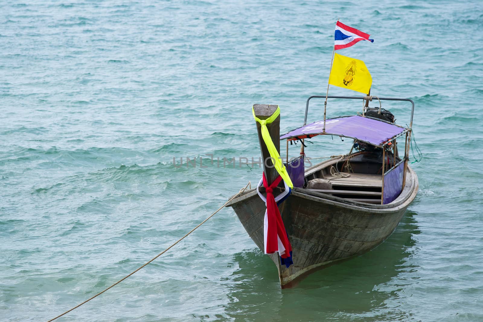 Traditional thai boat decorated with ribbons and flag