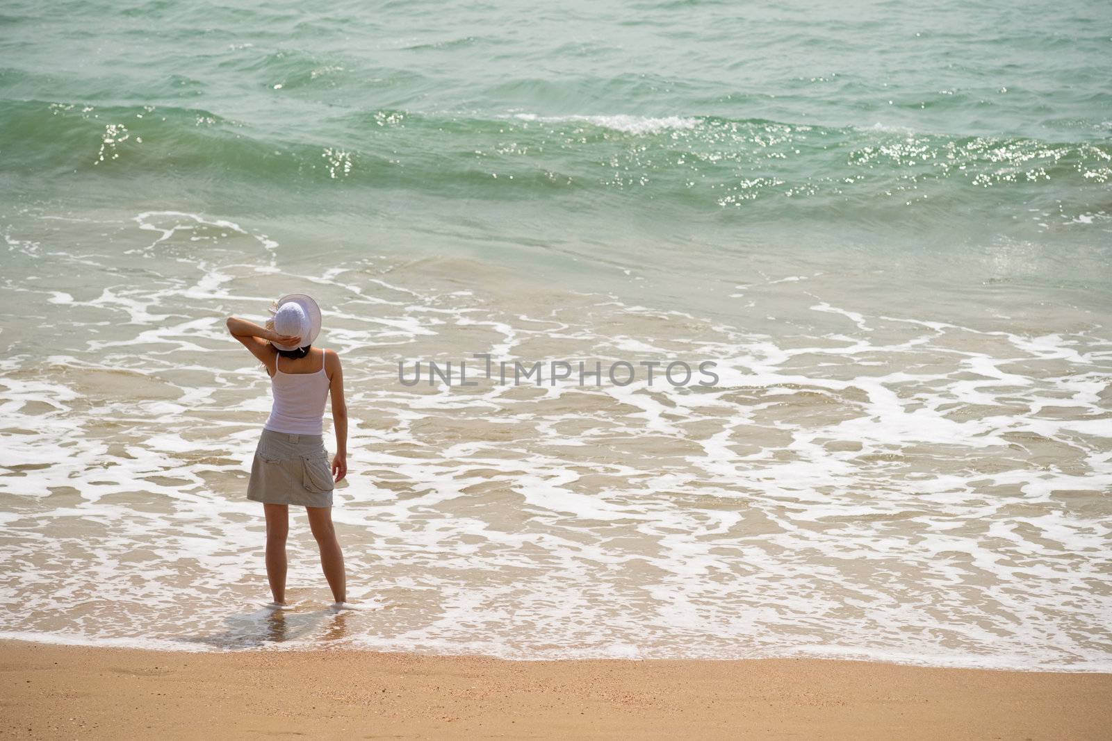 Woman standing in the sea waves 