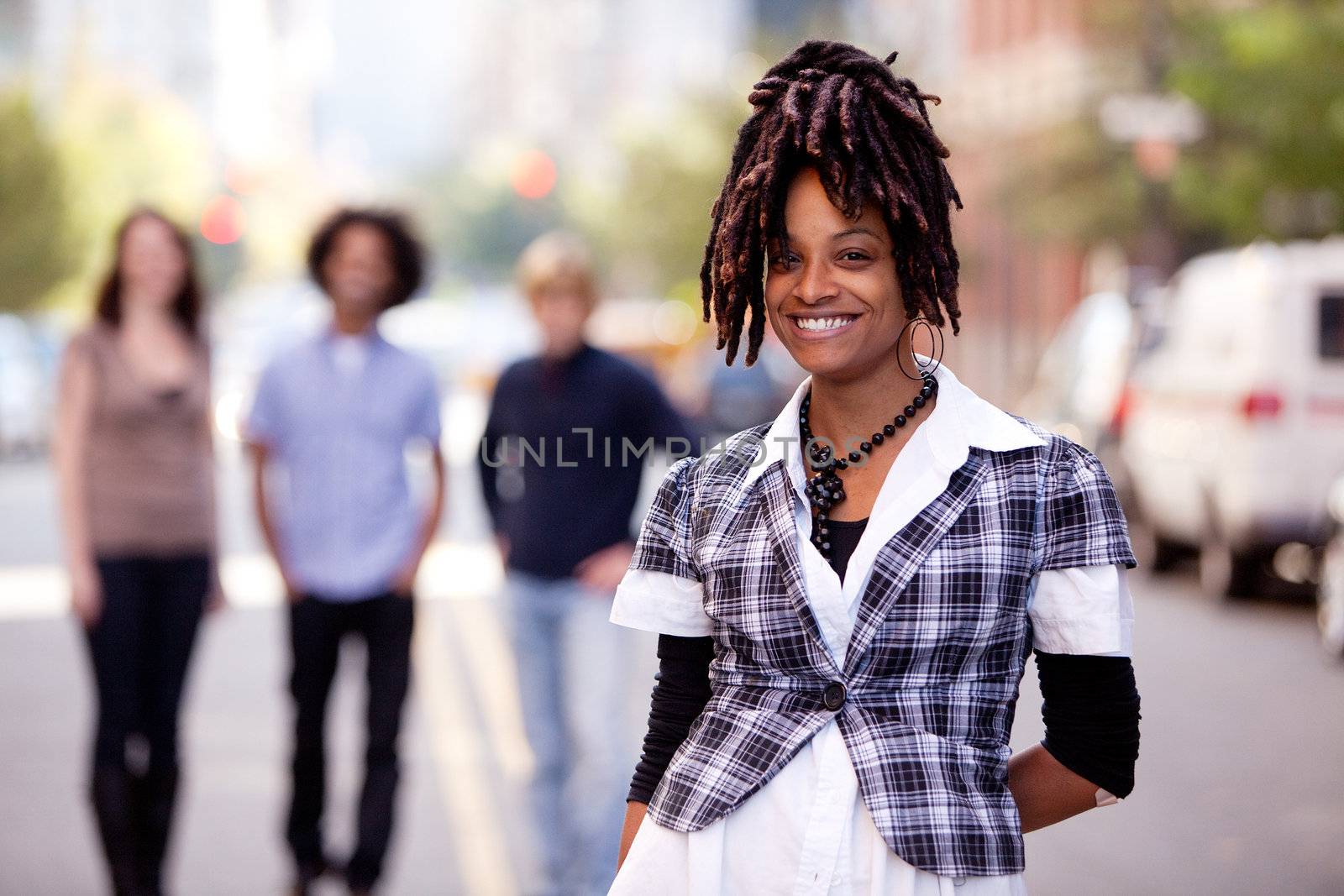 A pretty African American woman in the city with friends