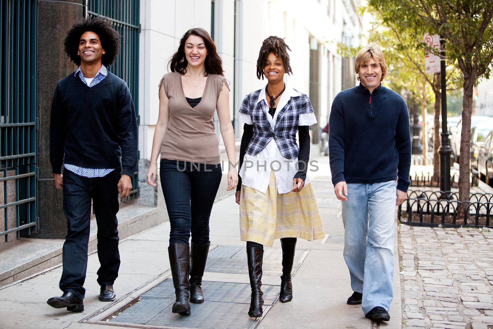 A group of friends walking on the sidewalk in an urban setting
