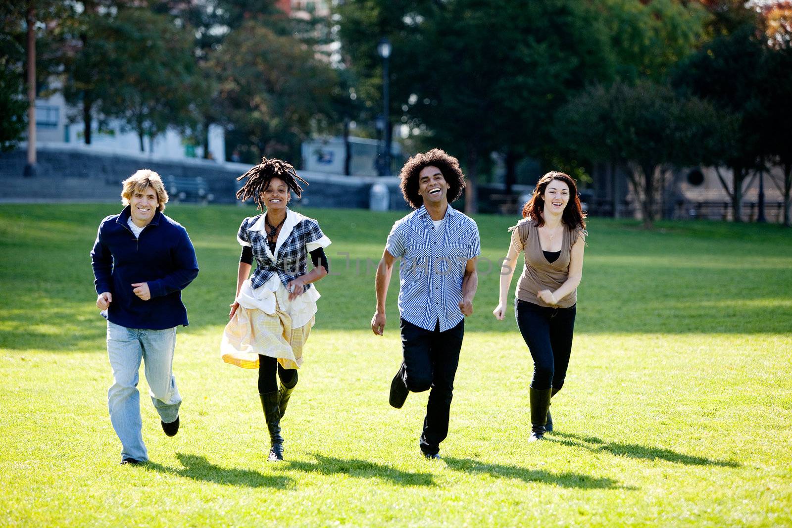 A group of people in a park, running towards the camera