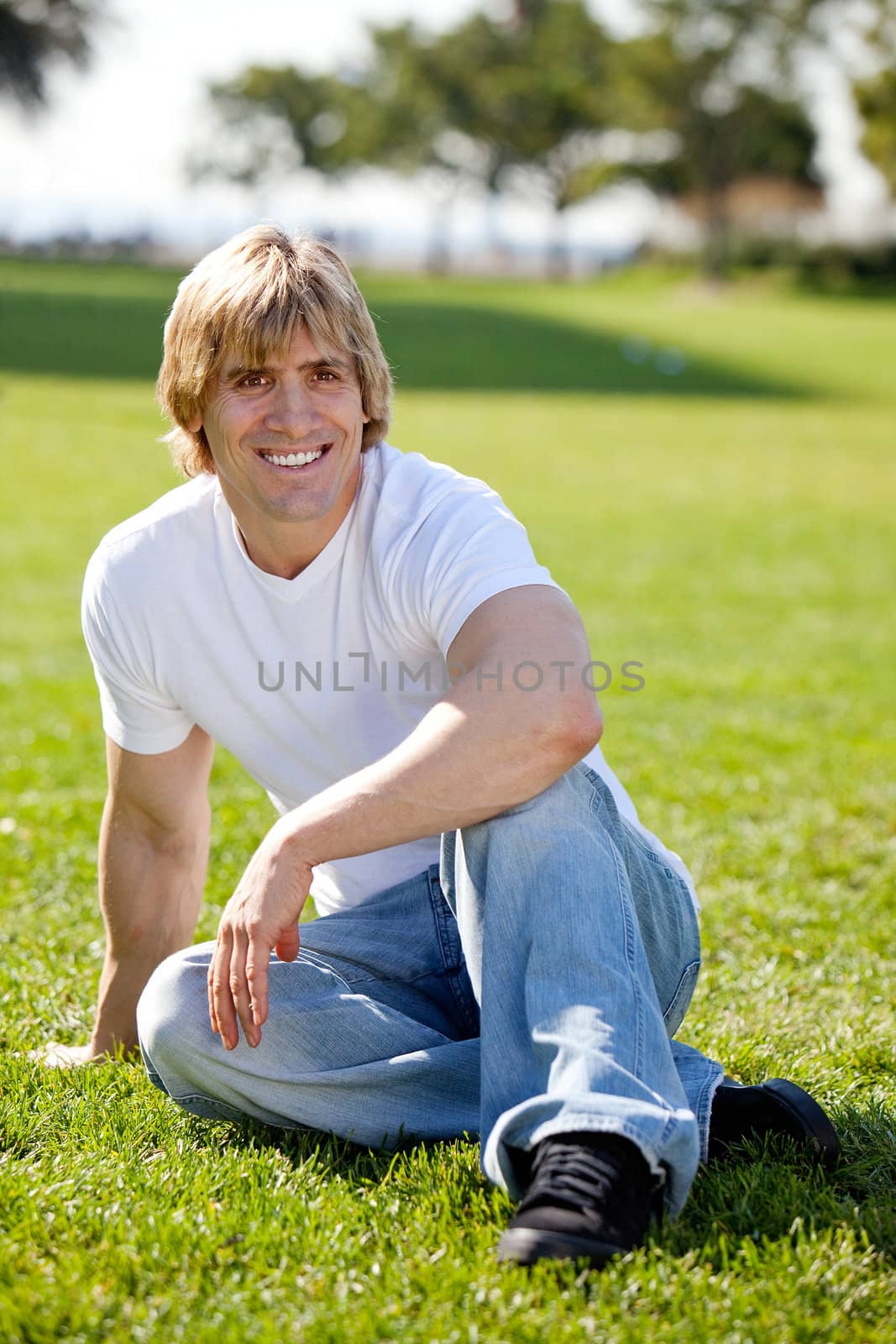 A fit adult male resting on grass