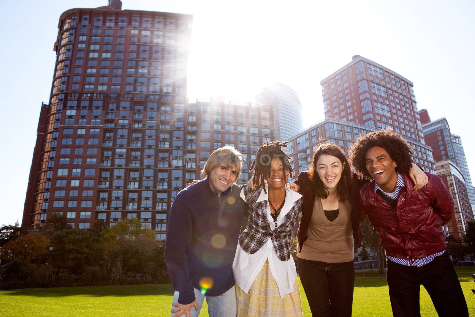 A group of young adults in a city park - shot into the sun with solar flare