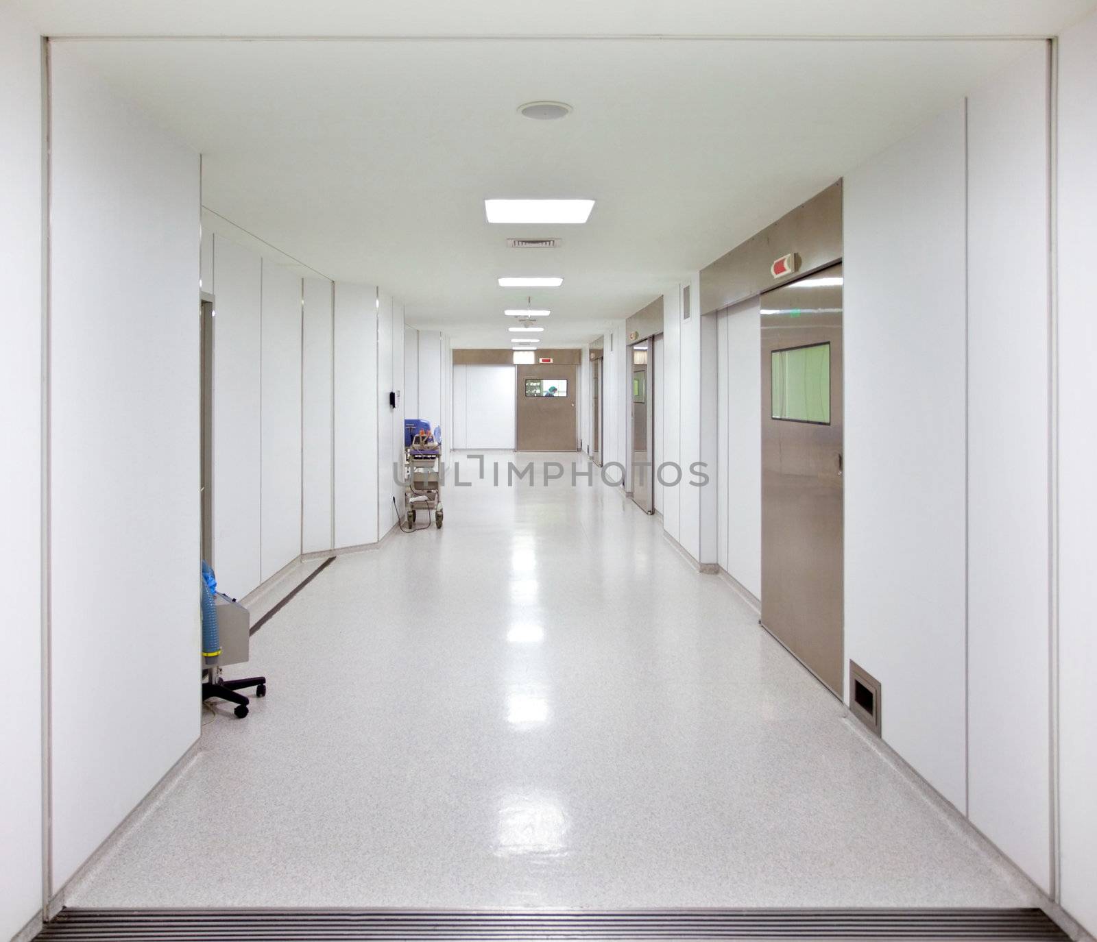 Long empty hospital surgery corridor with lamps turned on
