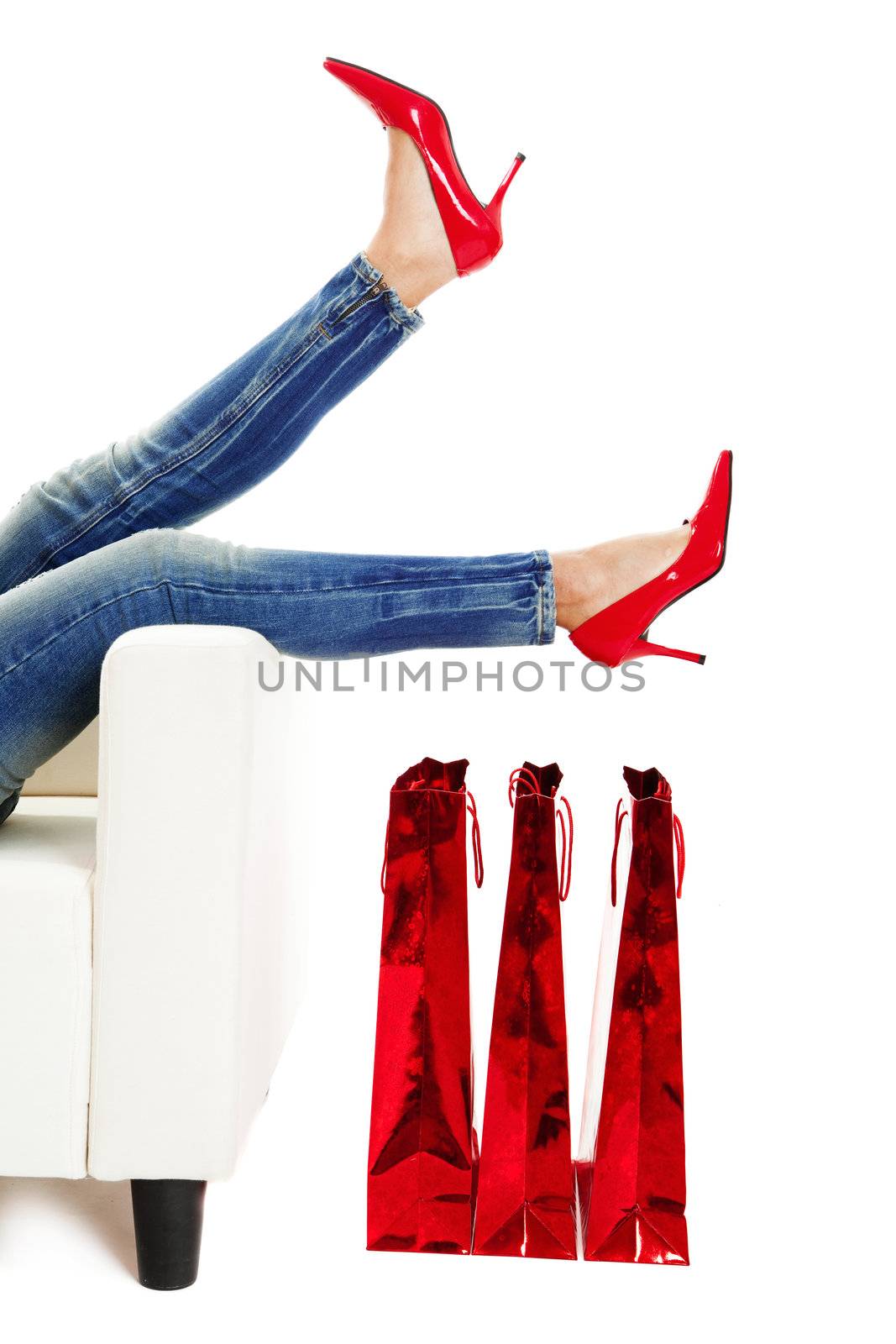 Female legs with sexy red shoes over christmas presents