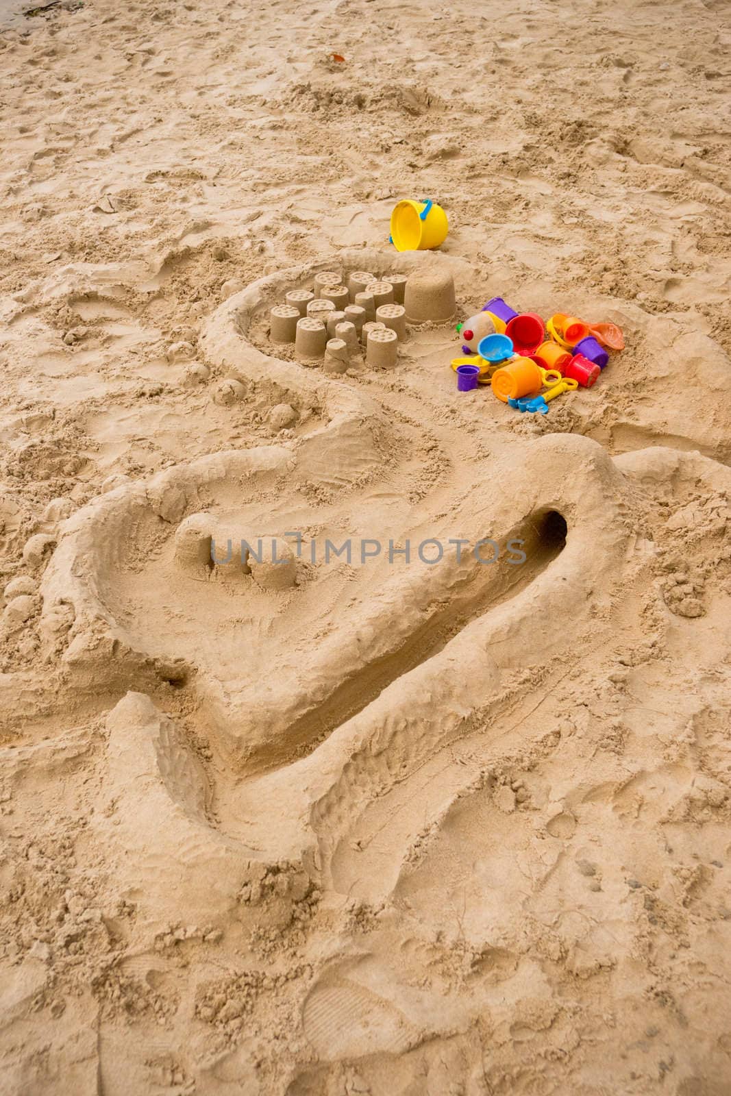 Children's multicolored toys on the sandy beach