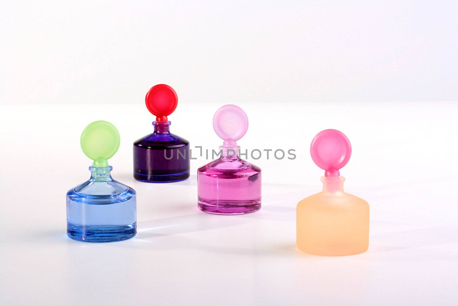 Colour small small bottles with cosmetics for care of a skin on a white background.