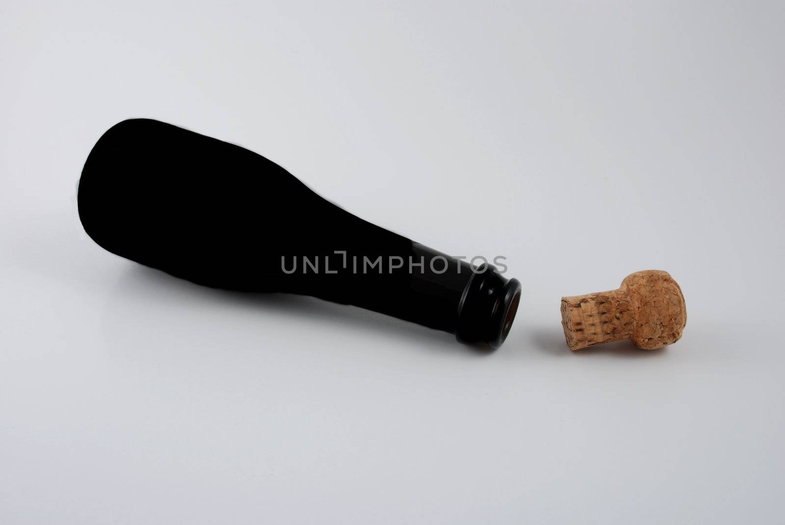 Pictures of an empty bottle of champagne with the cork at it side