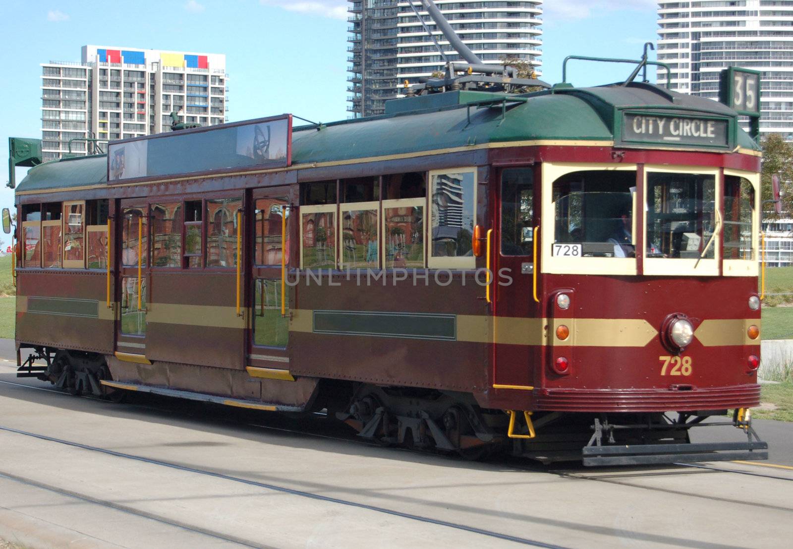 A Colourful photo of a Tram in motion, located in Melbourne Australia