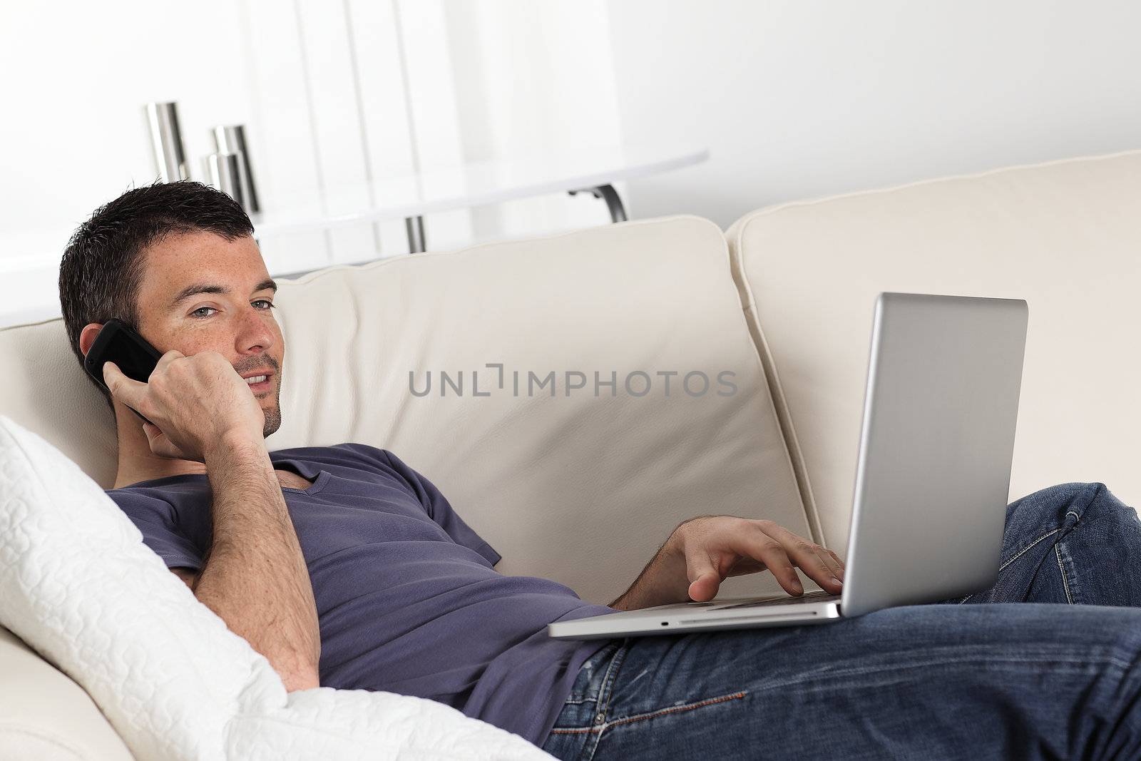 man on sofa with computer and phone by vwalakte