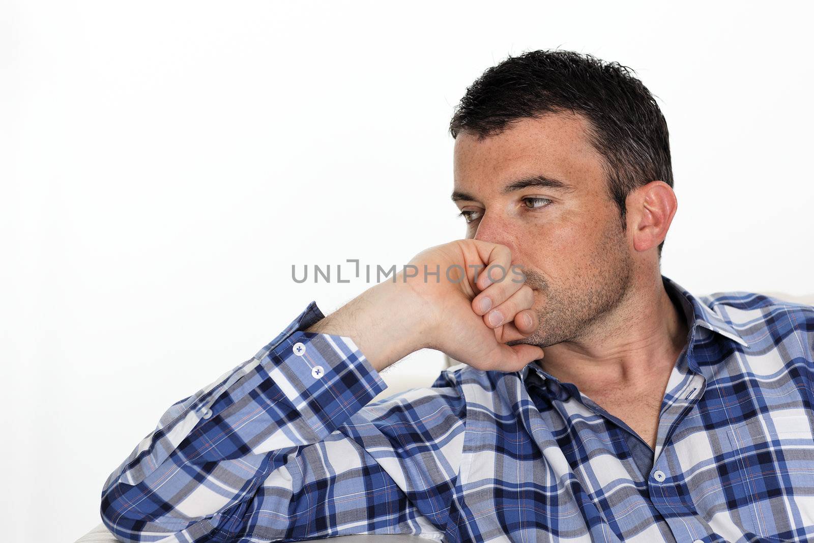 pensive man with blue shirt at home