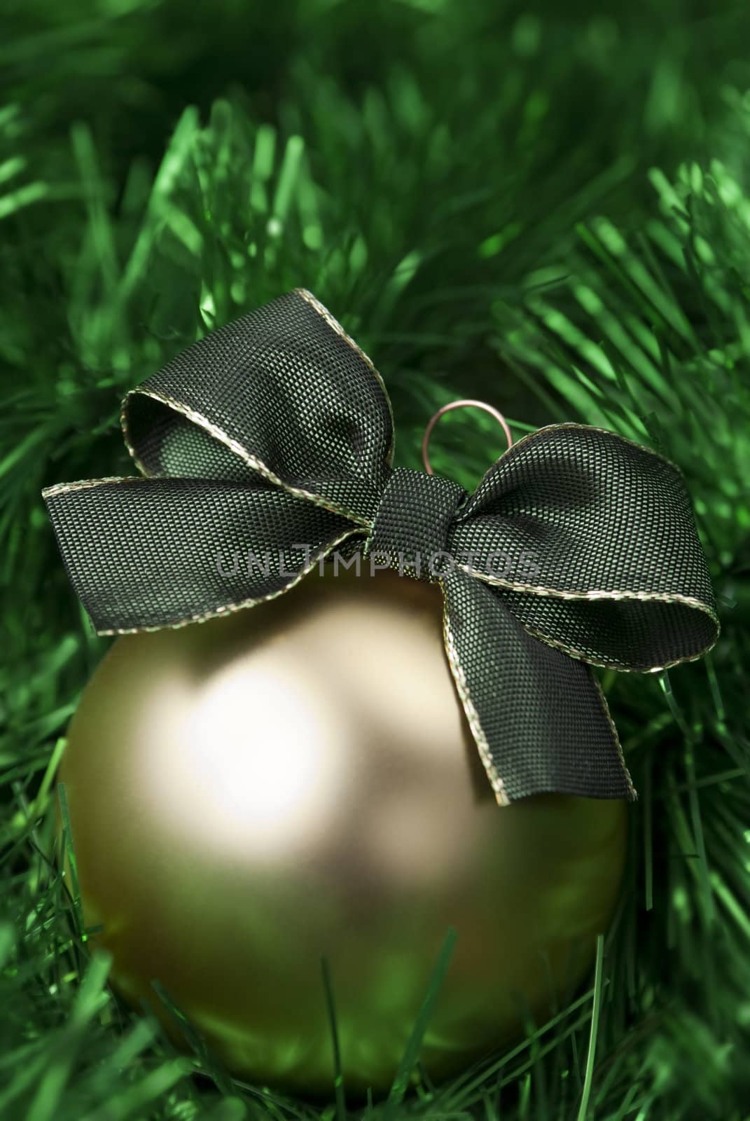 Gold christmas ball on the green tinsel. aRGB.