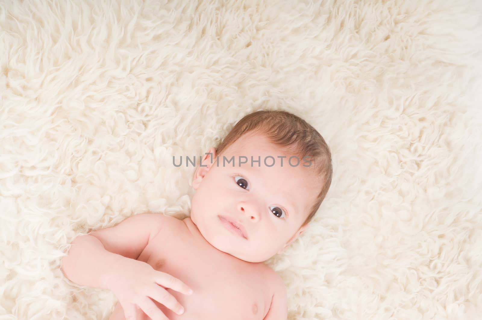 Newborn baby lying on the fur in studio