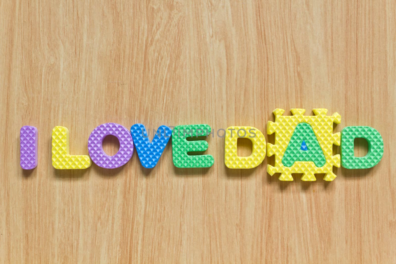 colorful letters with "I love dad" isolated on wood texture