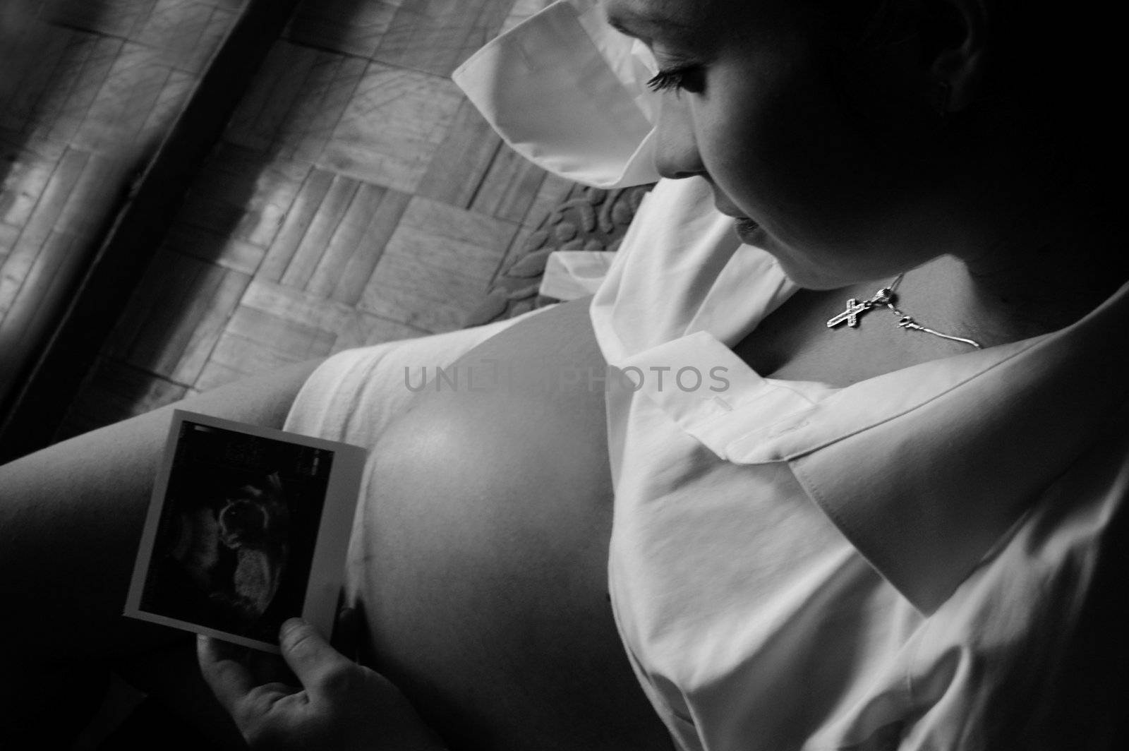 Close-up of beautiful pregnant woman holding baby echo on her belly