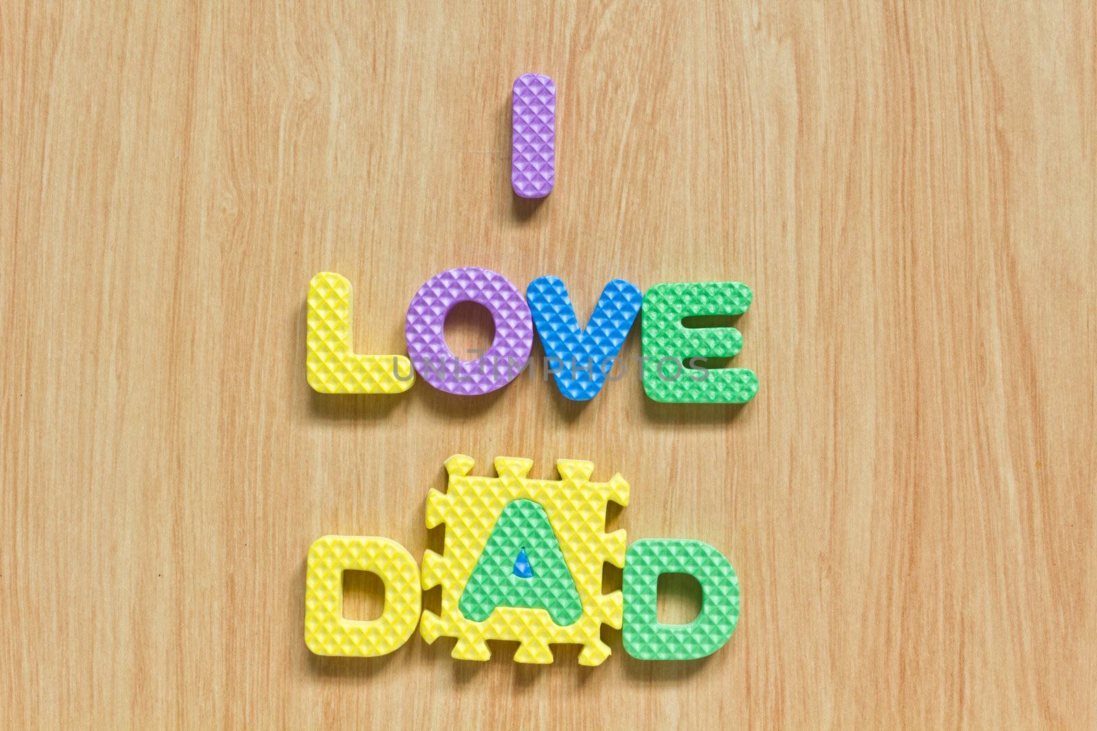 colorful letters with "I love dad" isolated on wood texture