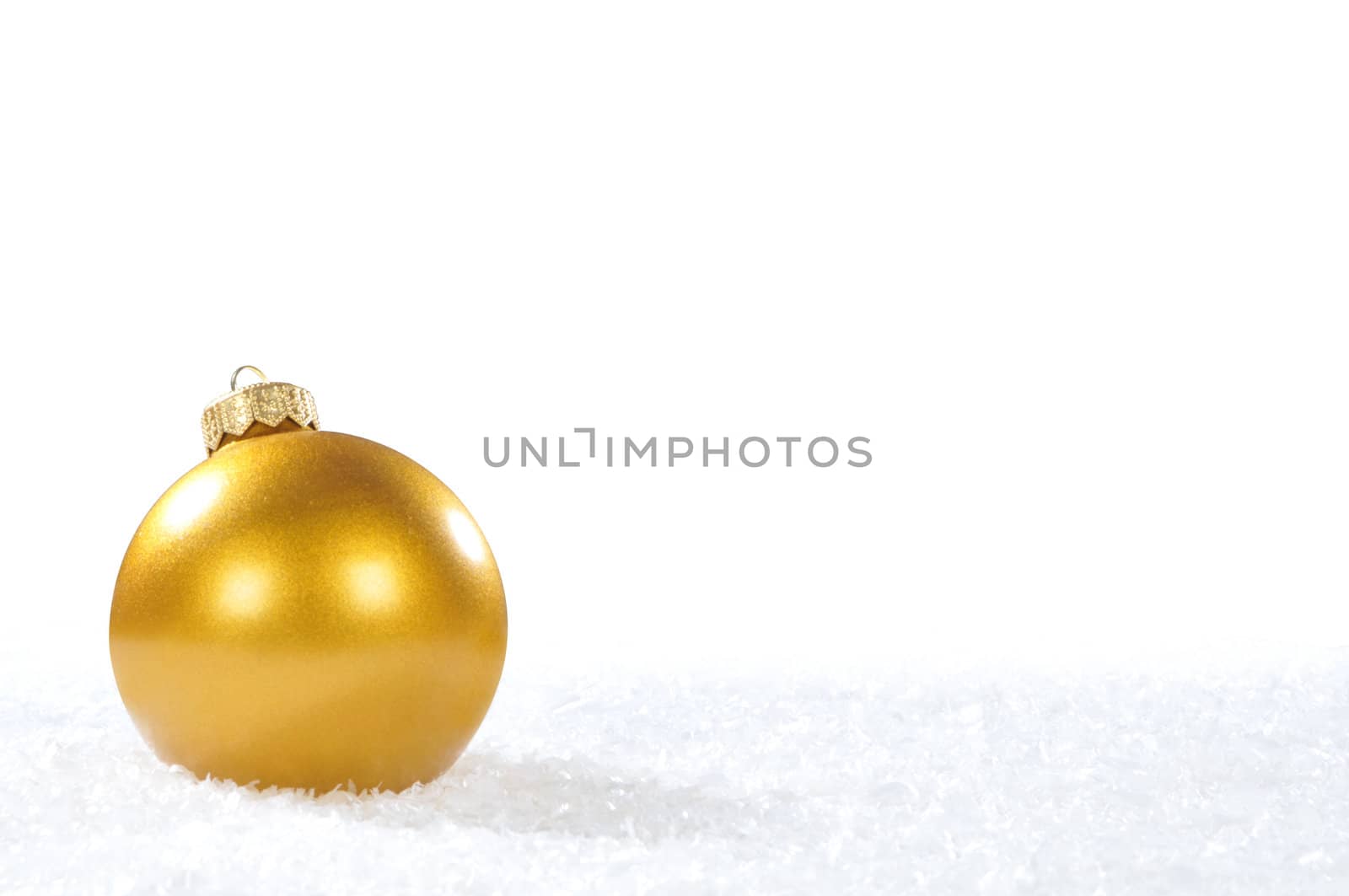 Gold christmas ball on white snow