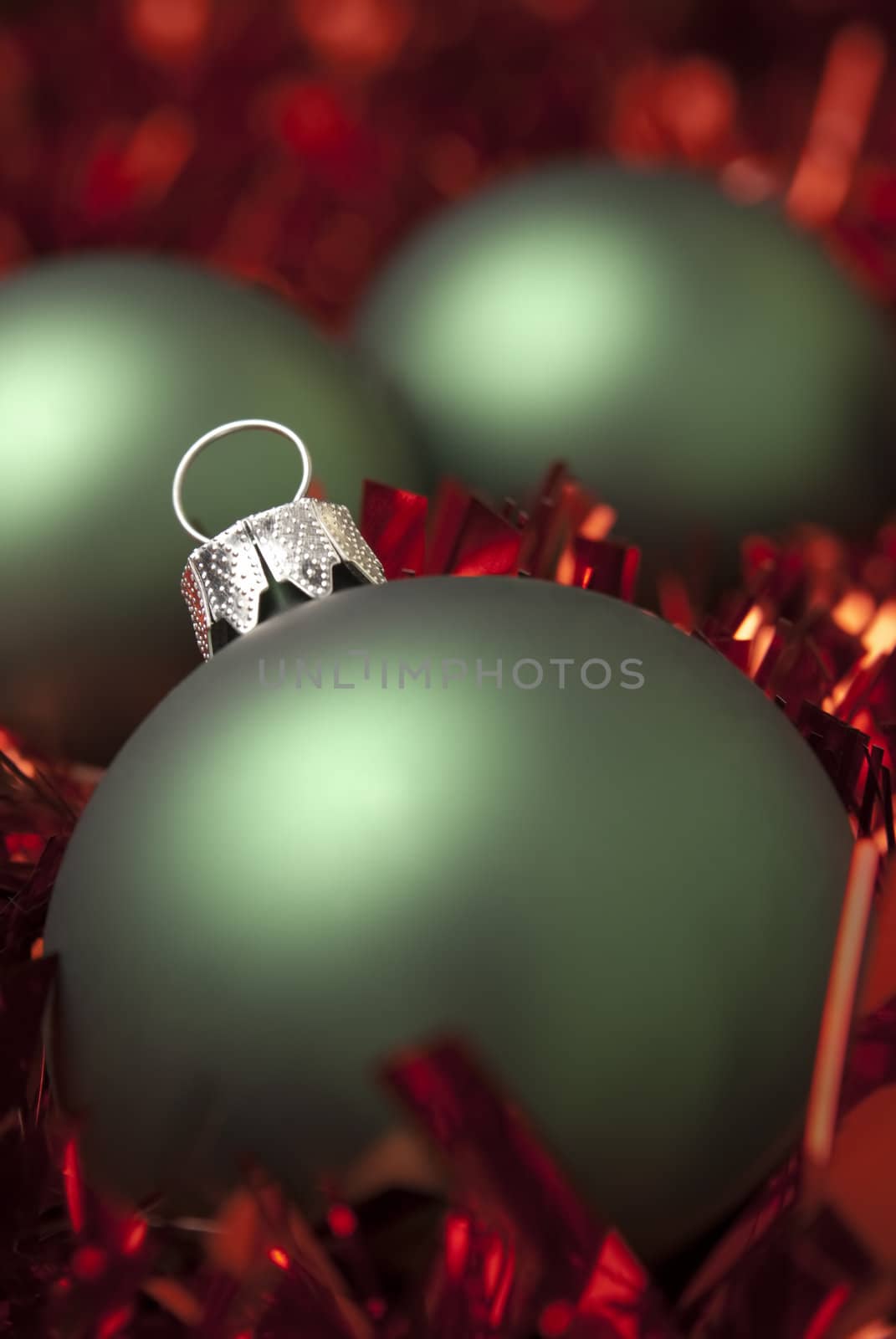 Green christmas ball on the red tinsel. aRGB.