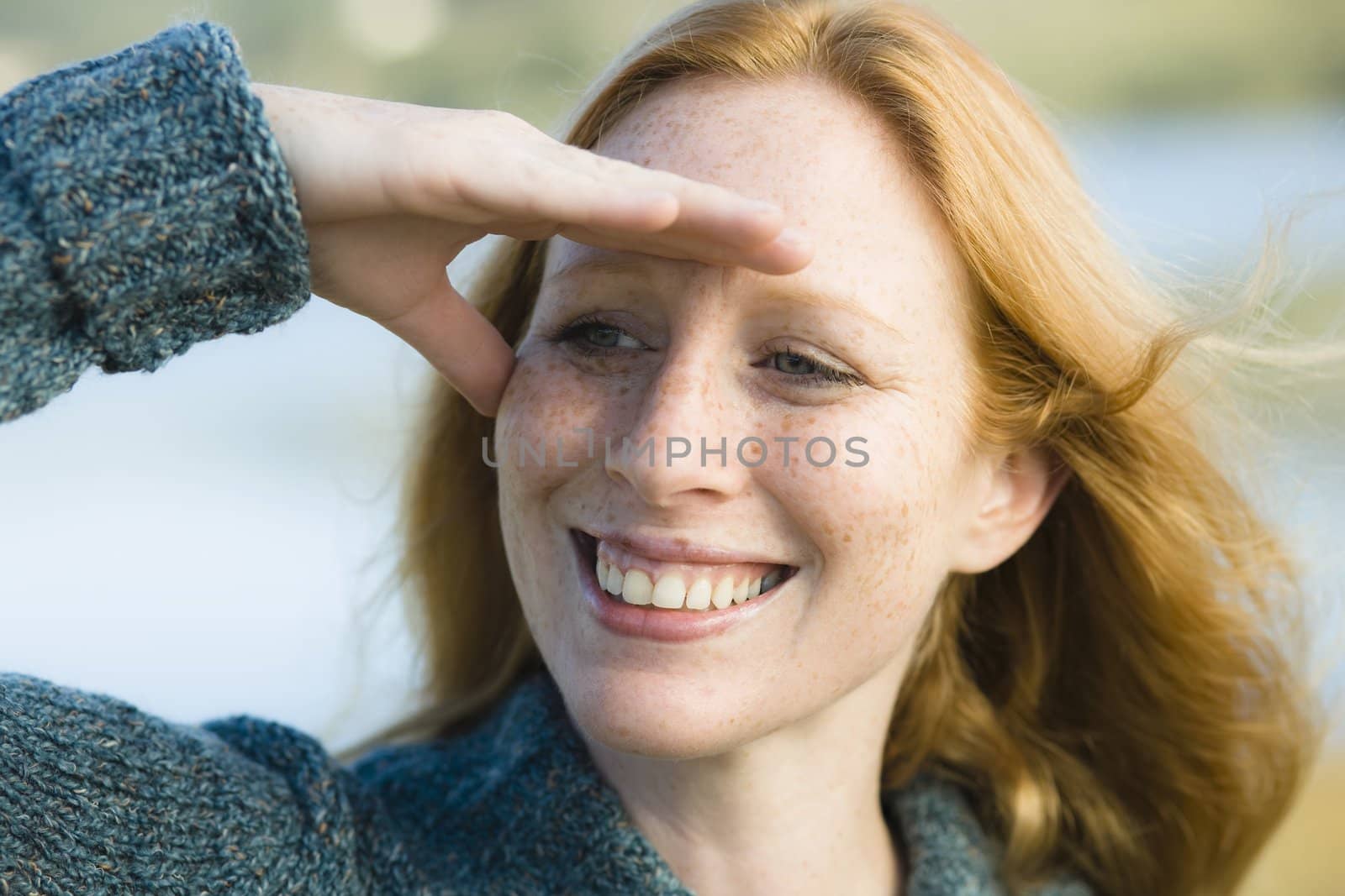 Portrait of a Pretty Redhead Woman Shielding Her Eyes