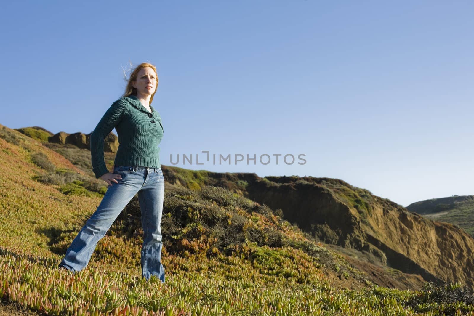 Portrait of a Pretty Redhead Woman Standing on Cliff