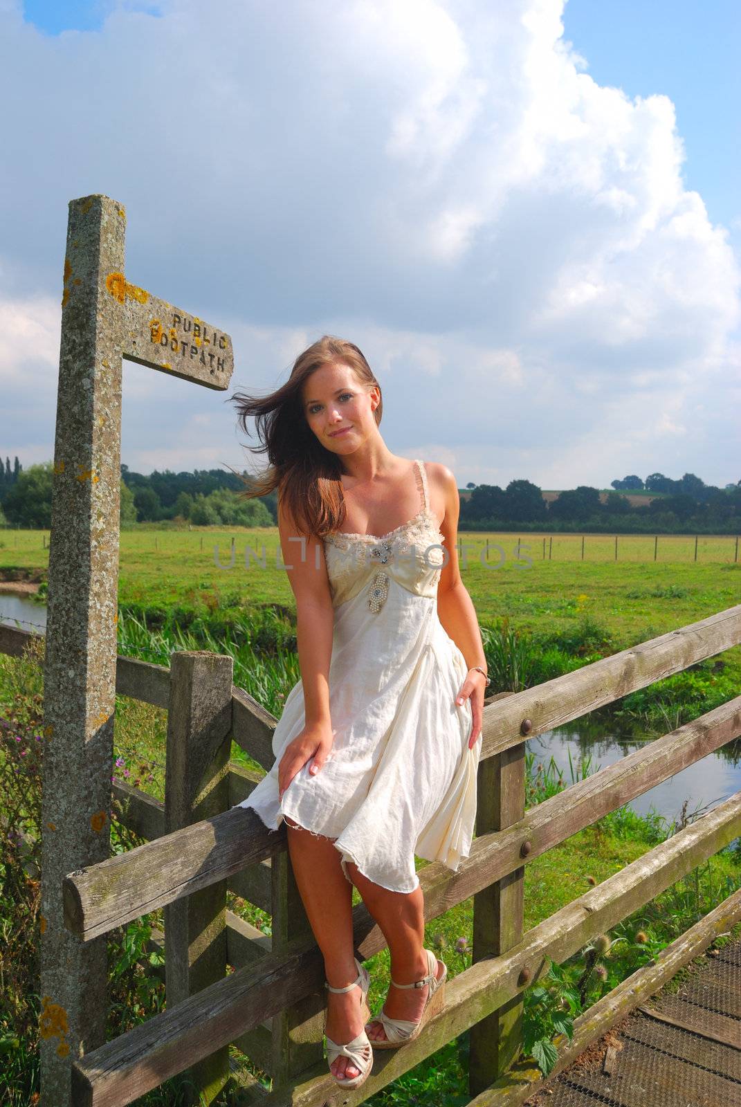 pretty girl sitting near footpath sign