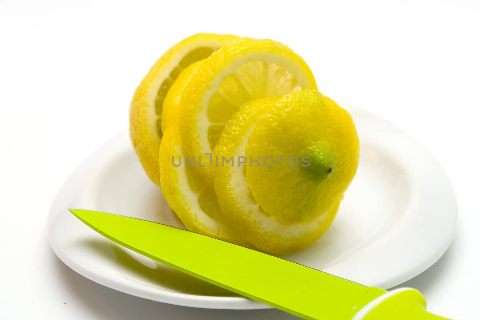 Yellow juicy lemon on a white plate on a white background