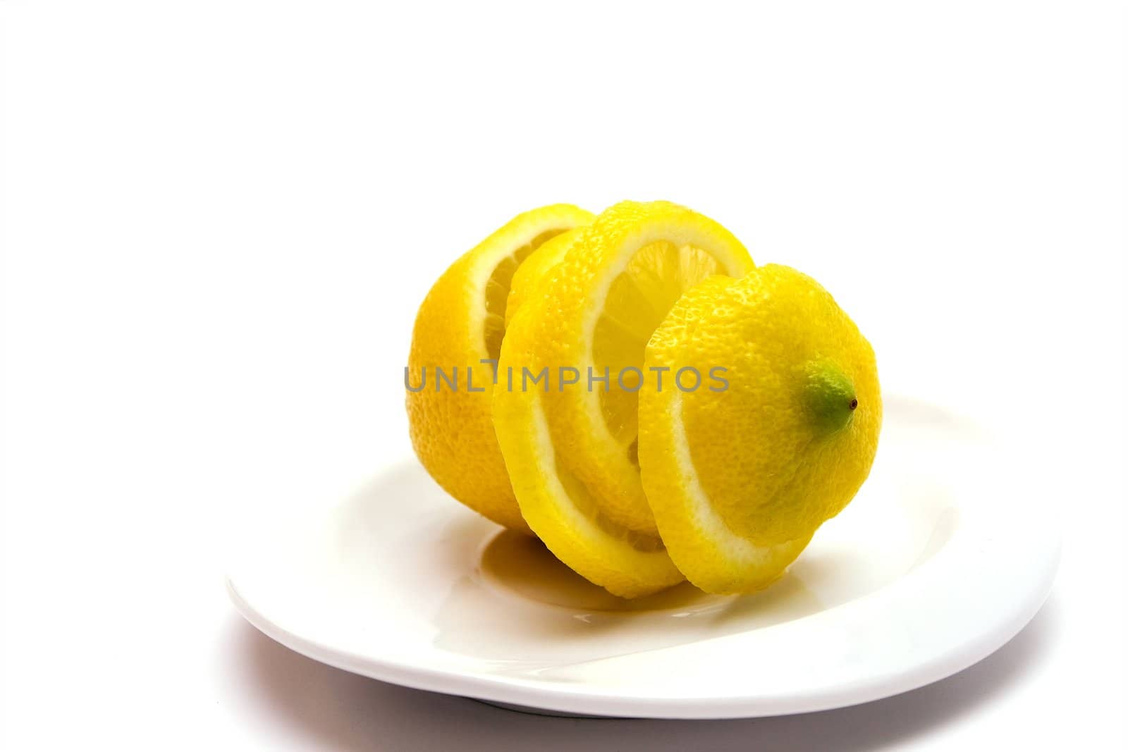 Yellow juicy lemon on a white plate on a white background