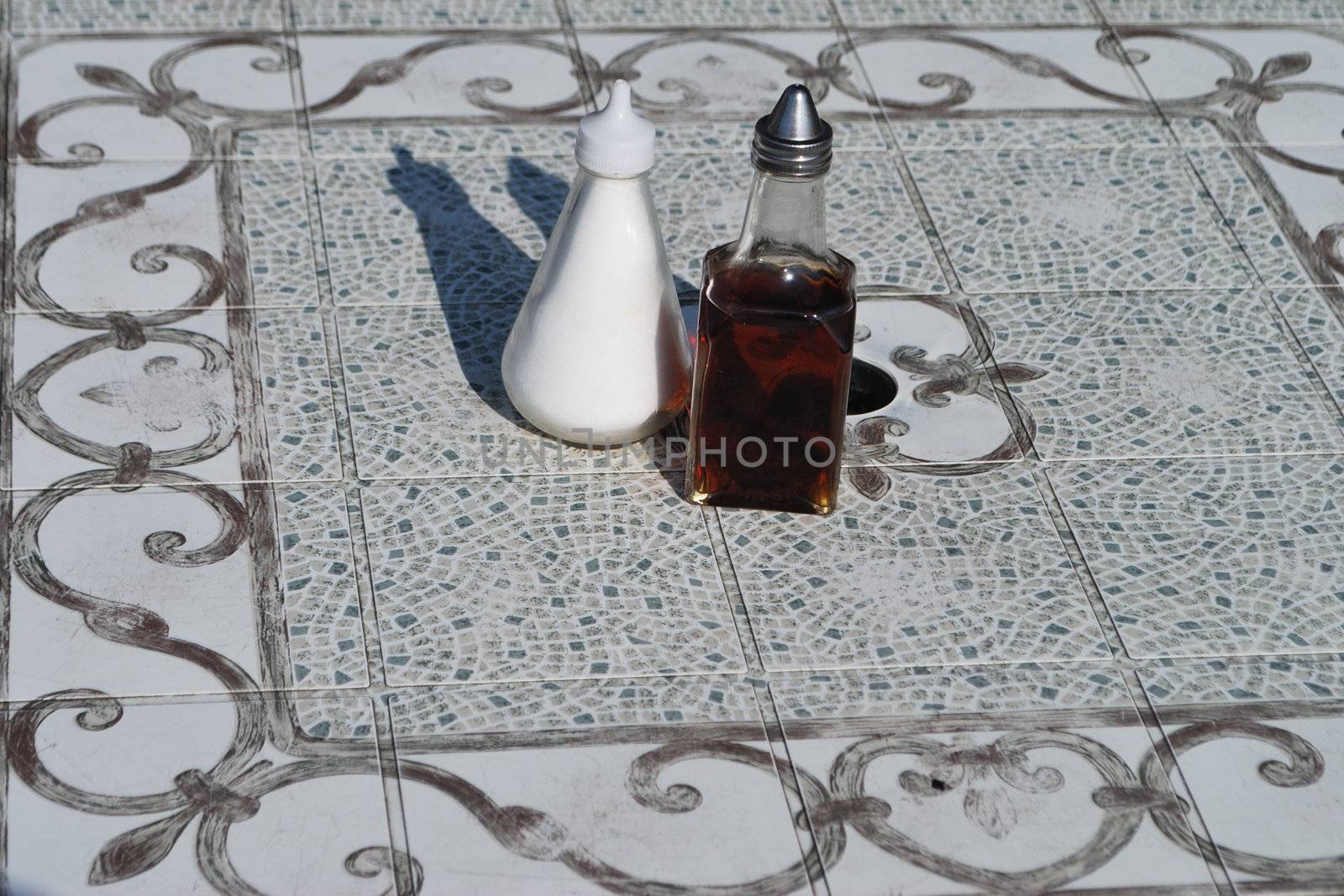 Salt and vinegar jars on tile table