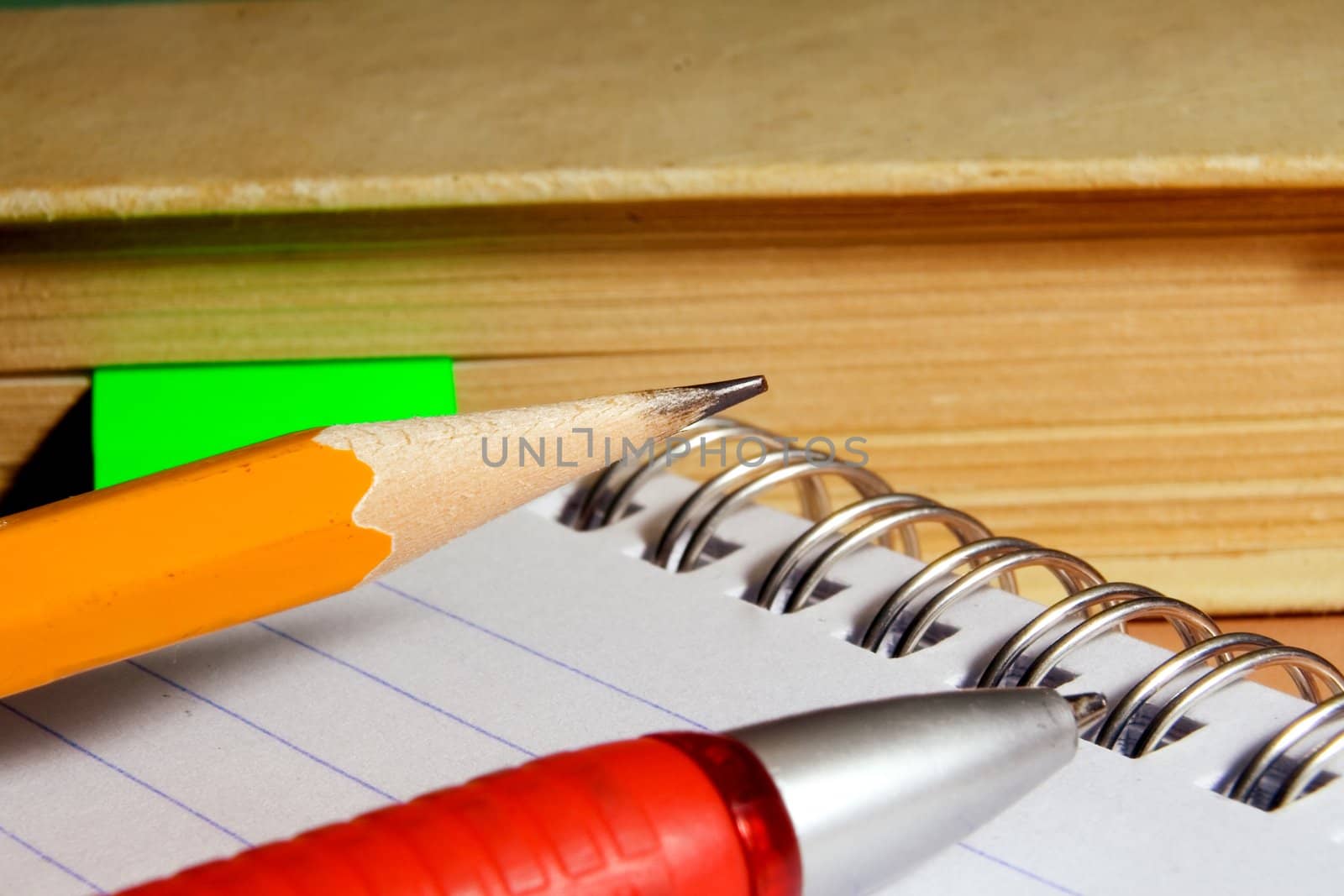 Notebook for notes, the book, the pen, a pencil on a desktop