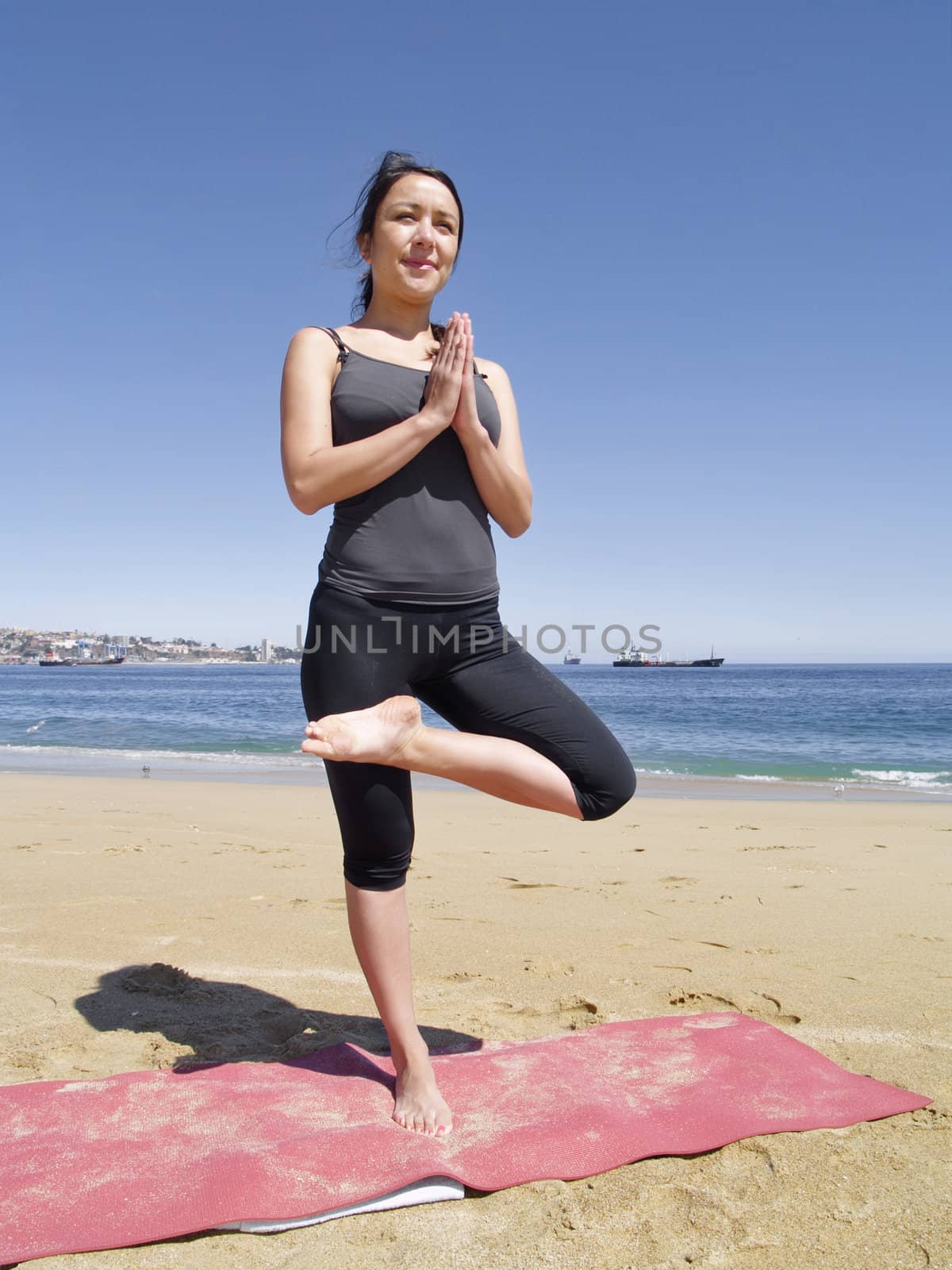 Yoga teacher practising at the beach pose tadasana