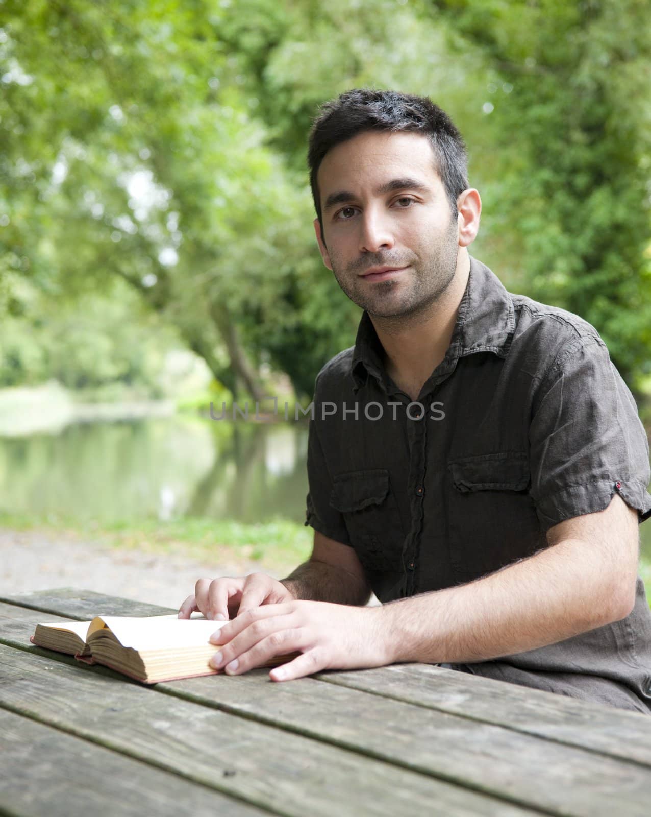 Man reading beside a canal