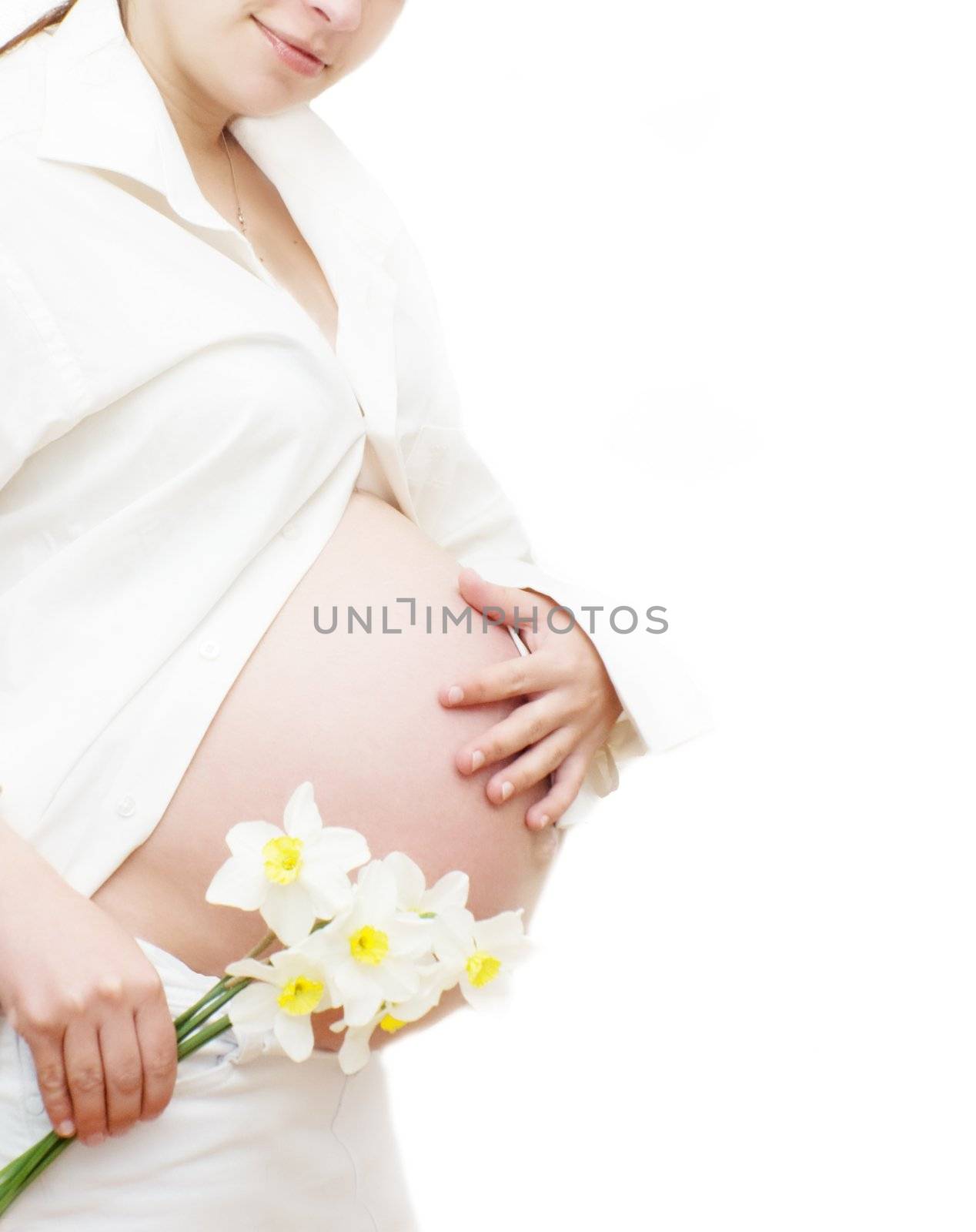 Part of pregnant woman with flower over white, last trimester