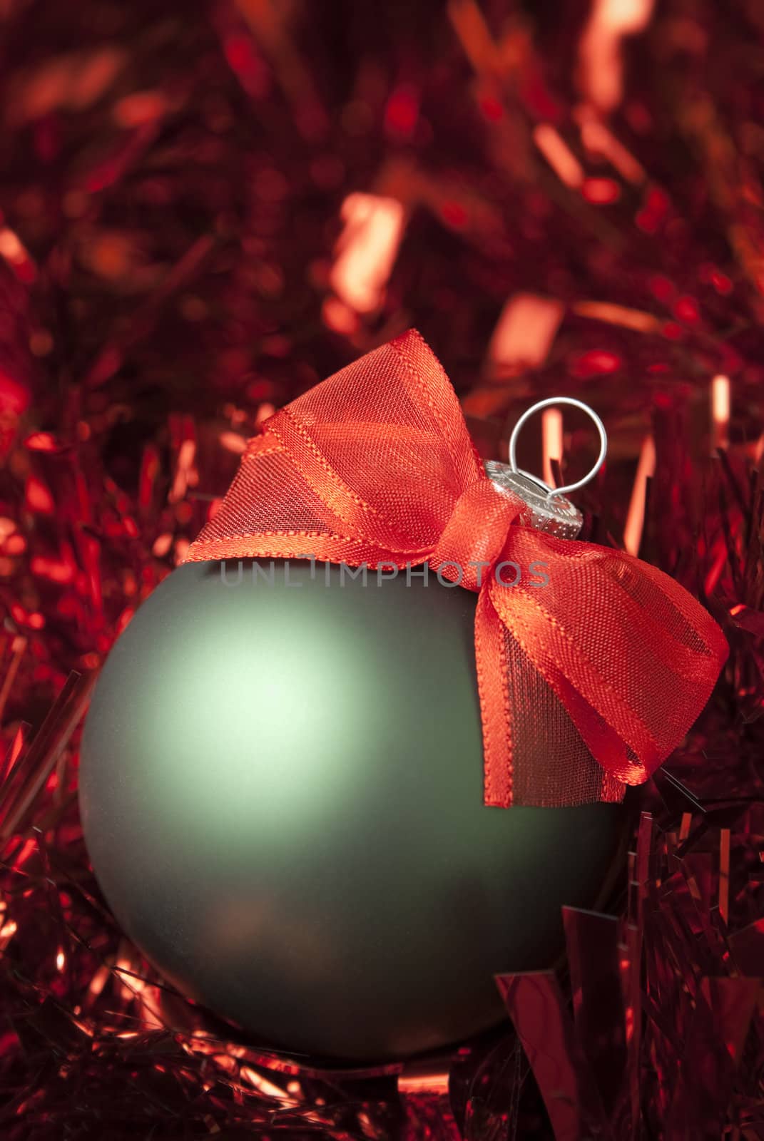 Green christmas ball on the red tinsel. aRGB.