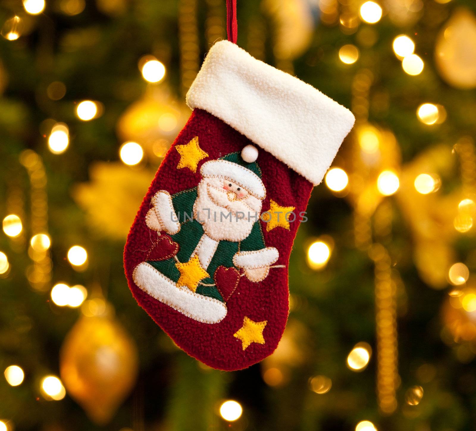 Close up of child's christmas stocking in front of out of focus Christmas tree