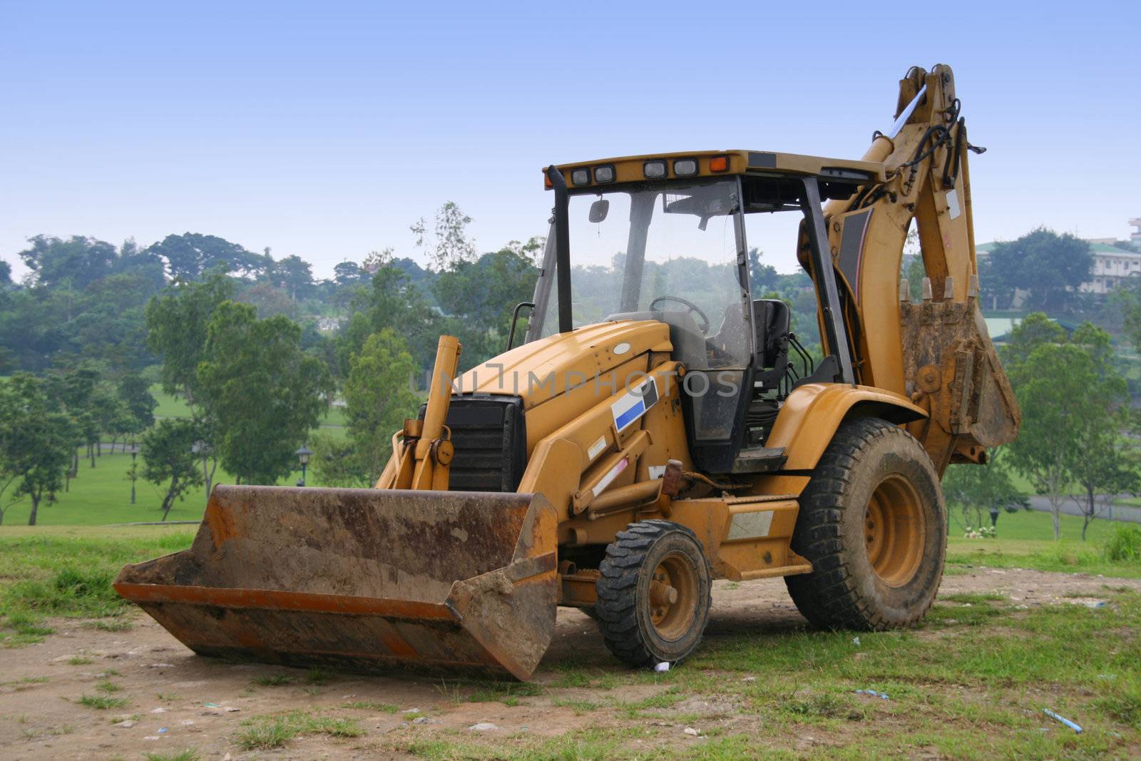 orange power shovel parked on an open field
