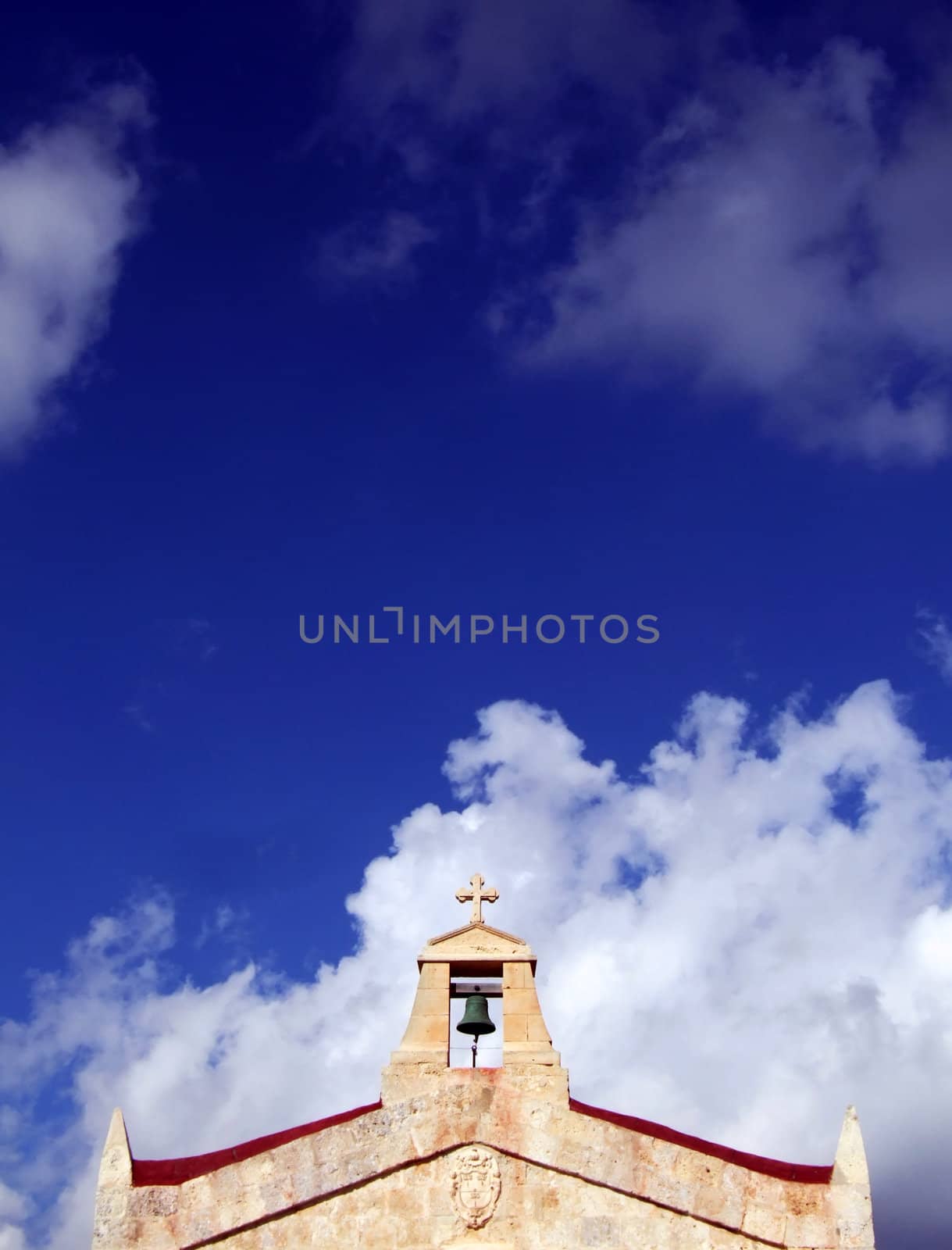 A medieval clocktower against blue sky and clouds