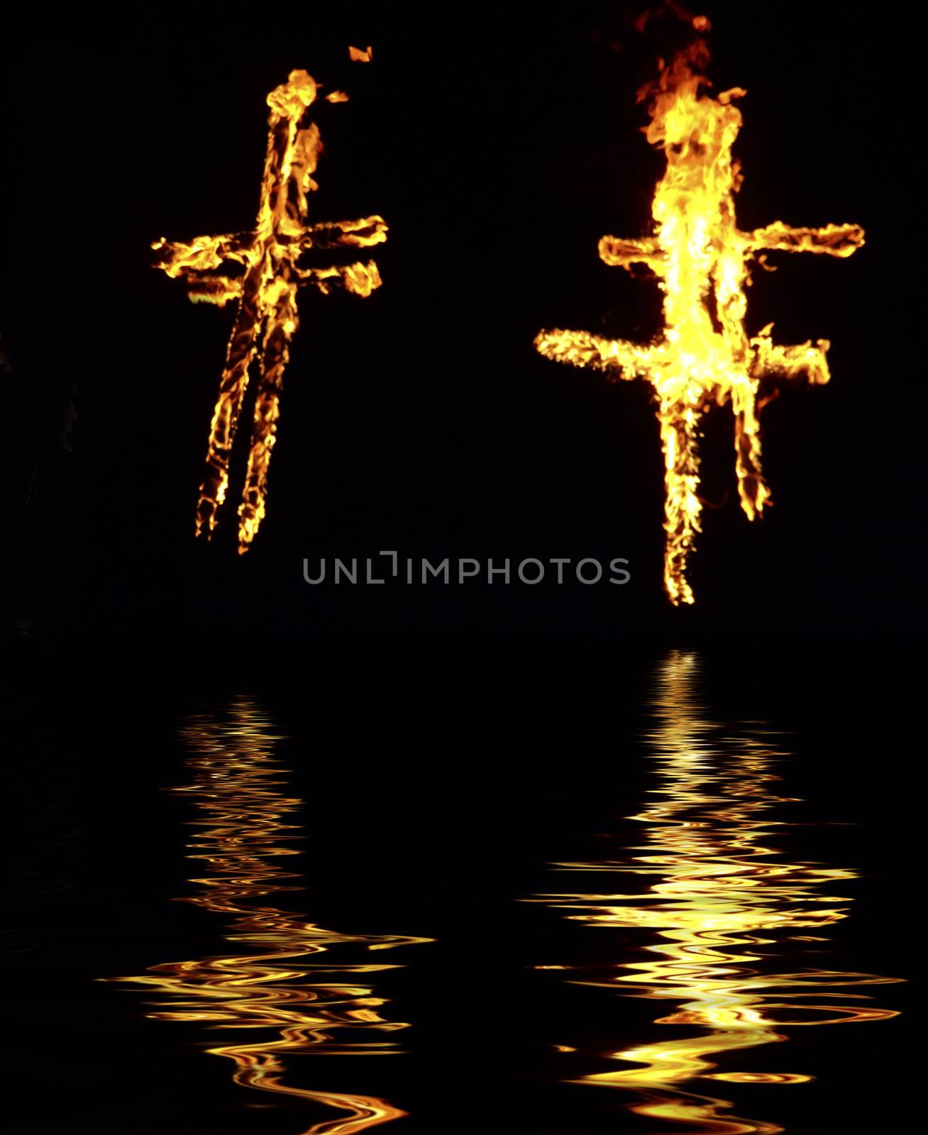 Burning crosses being used as part of ritual, on black background