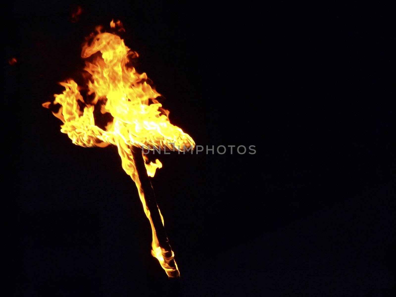 Burning crosses being used as part of ritual, on black background