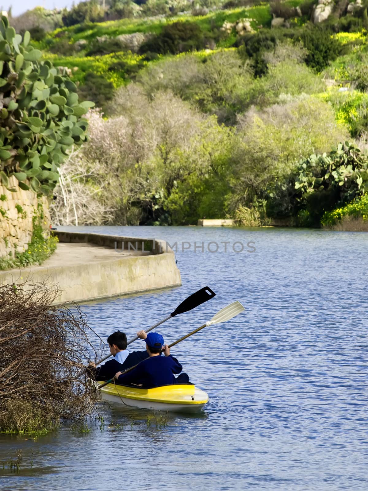 Young children canoeing in a rainwater river in Malta