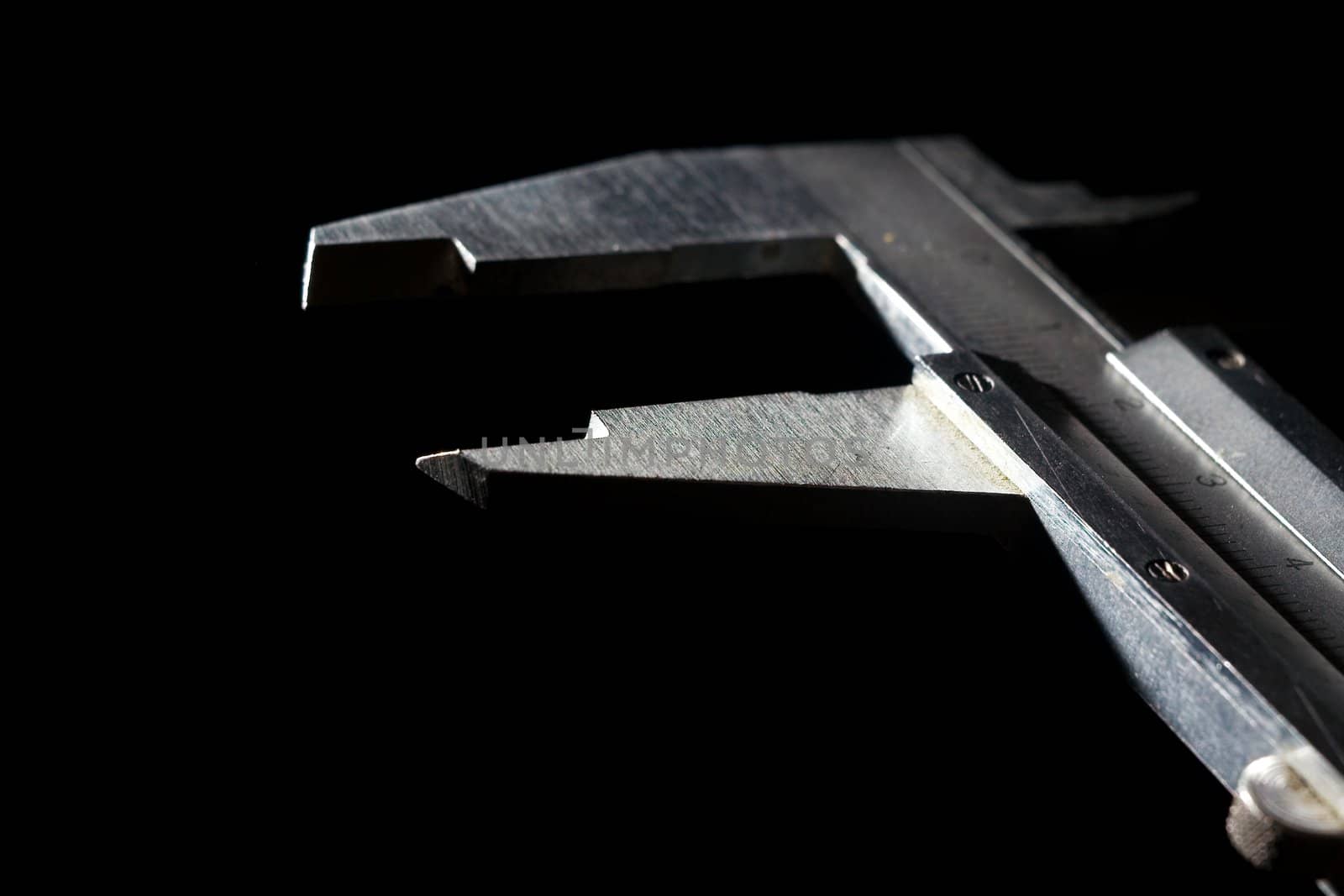 Stainless steel caliper on black background. Closeup