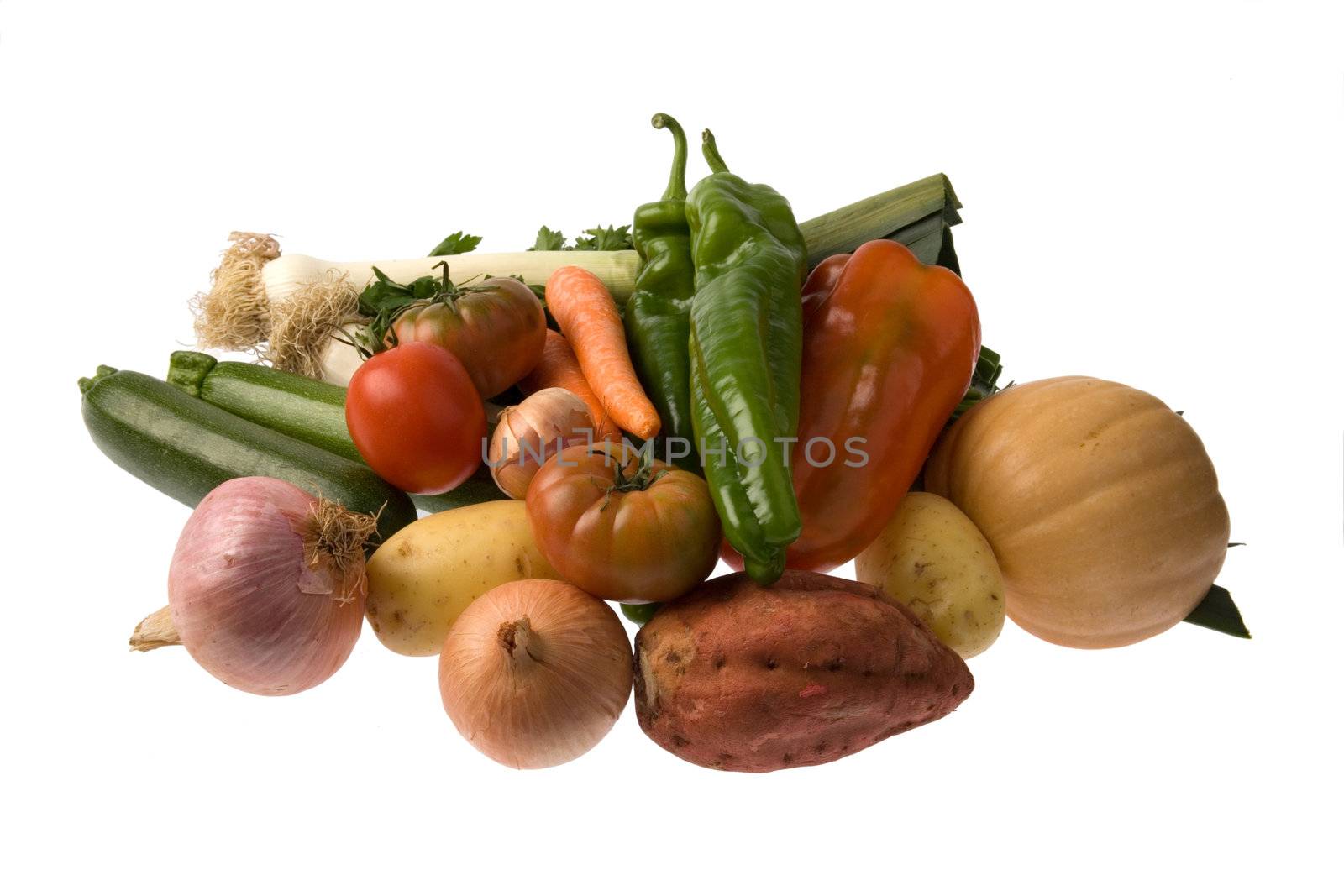 Arrangement of red and green peppers, onion, pumpkin, potatoes and sweet potatoes, pumpkin, carrots, tomatoes, parsley and zucchini isolated over white background.