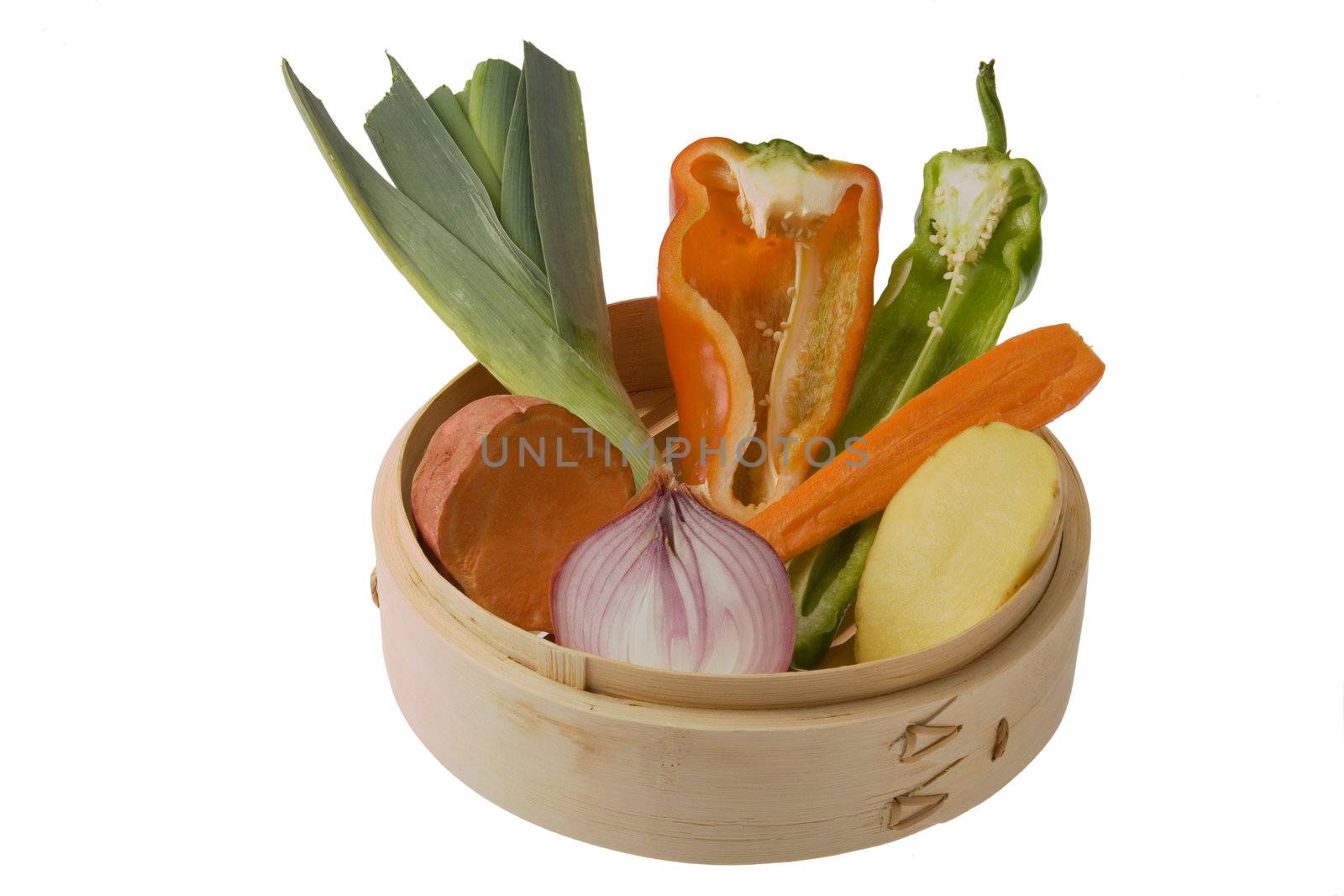 Pieces of  peppers, leeks, onion, carrot, potatoes and sweet potatoes in a bamboo steamer.