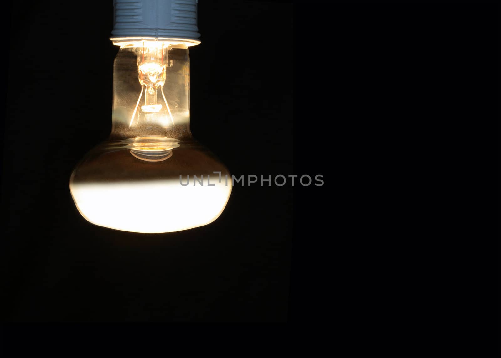 Luminous light bulb isolated on black background with copy space
