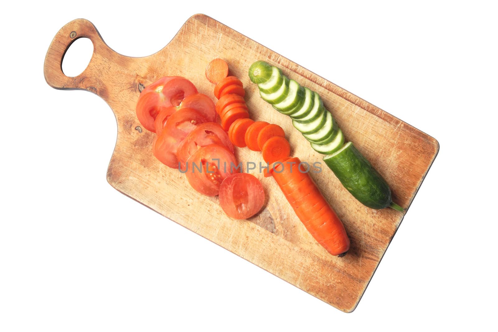 Various sliced vegetables on wooden breadboard. Isolated with clipping path