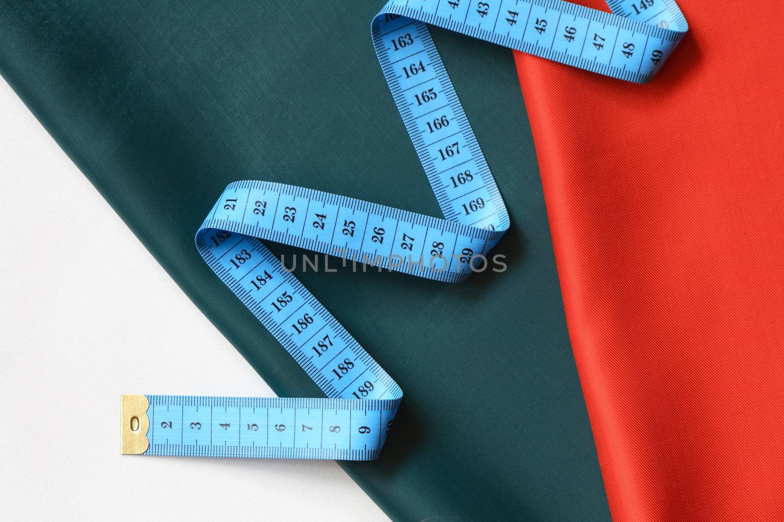 Blue tape measure on background with colored cloth