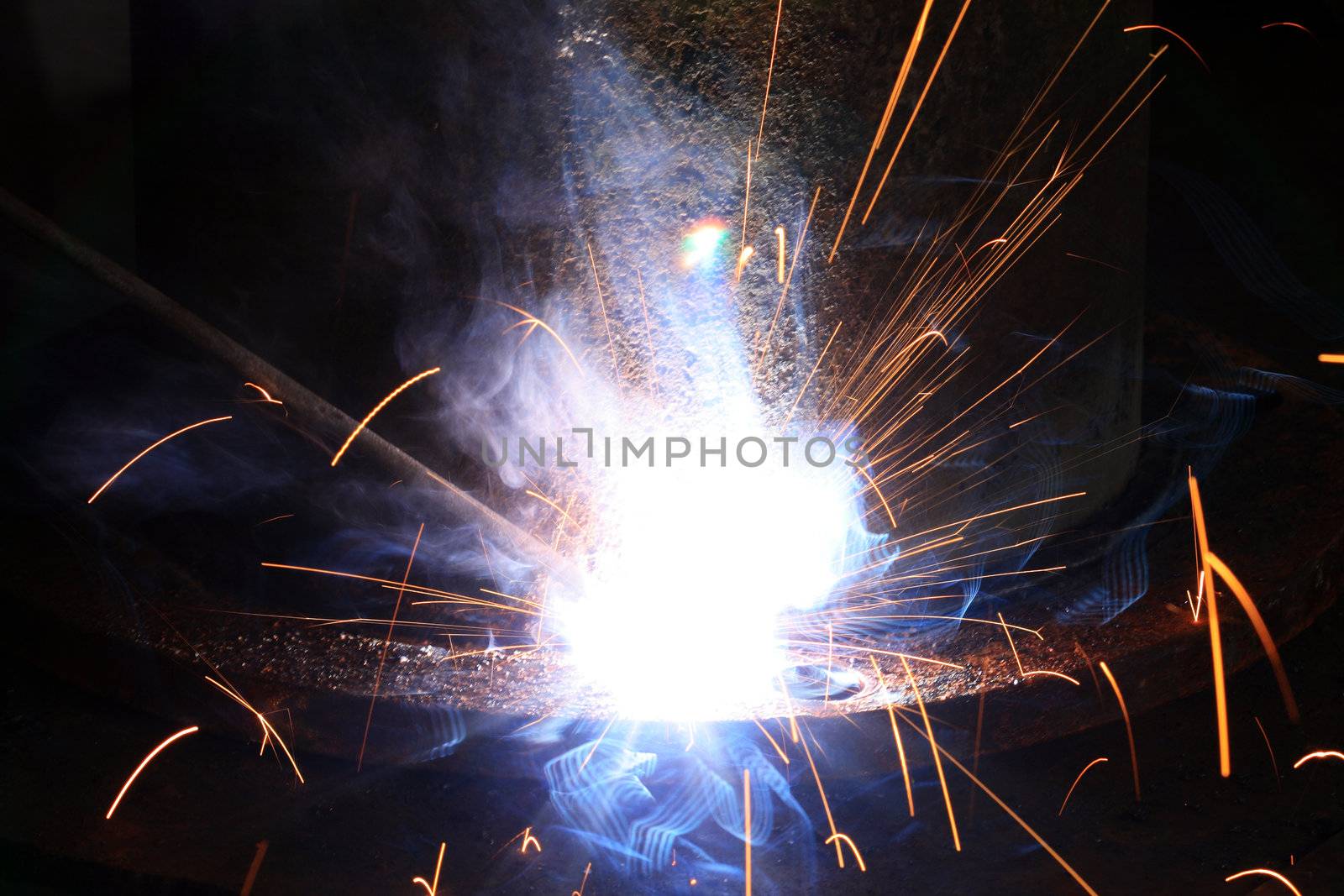 Closeup of welding's flame and sparks on dark background