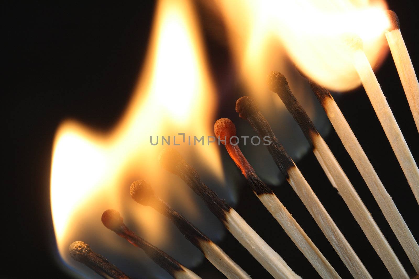 Closeup of few burning matches on dark background with copy space