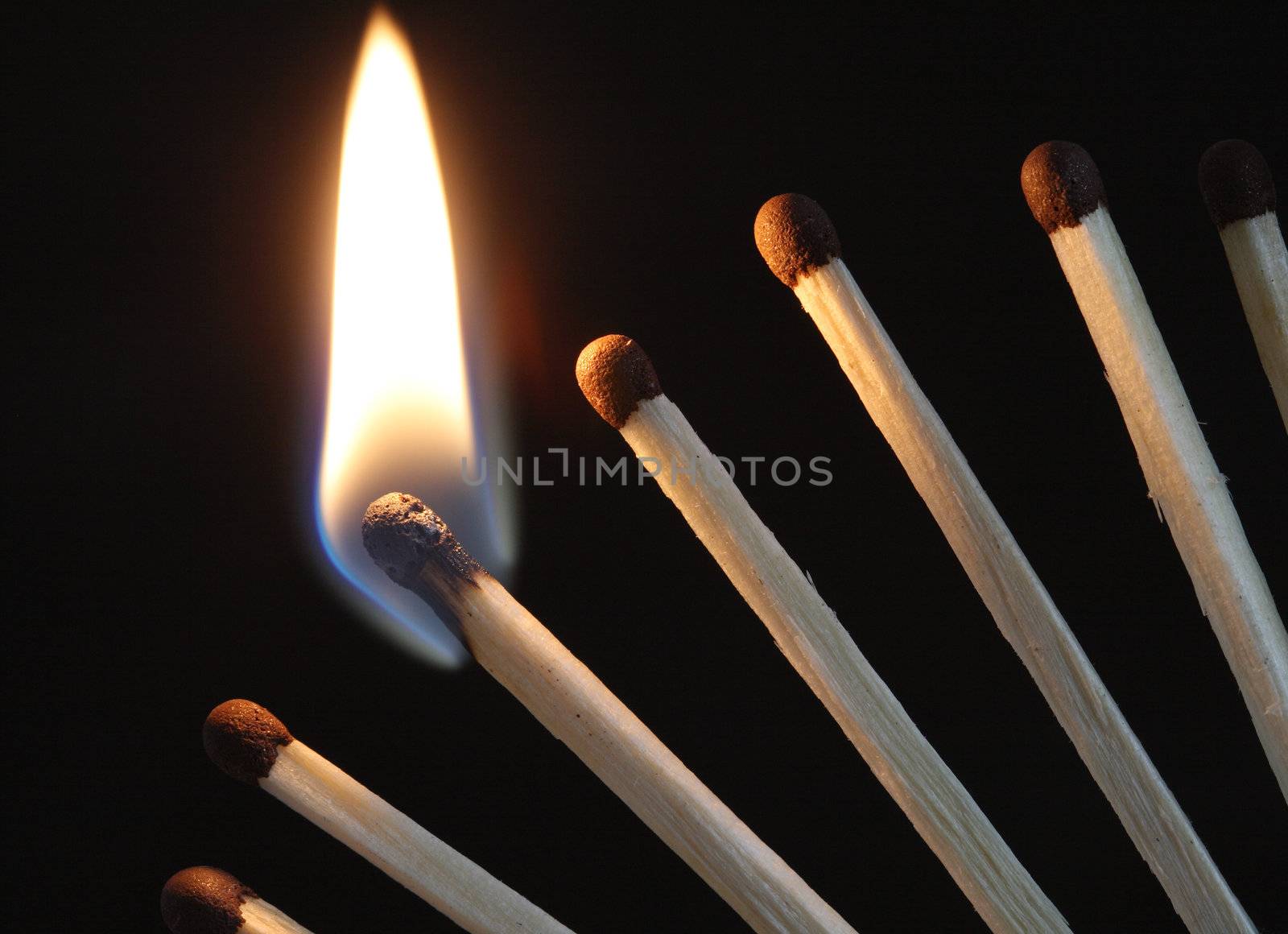 Closeup of few burning matches on dark background with copy space