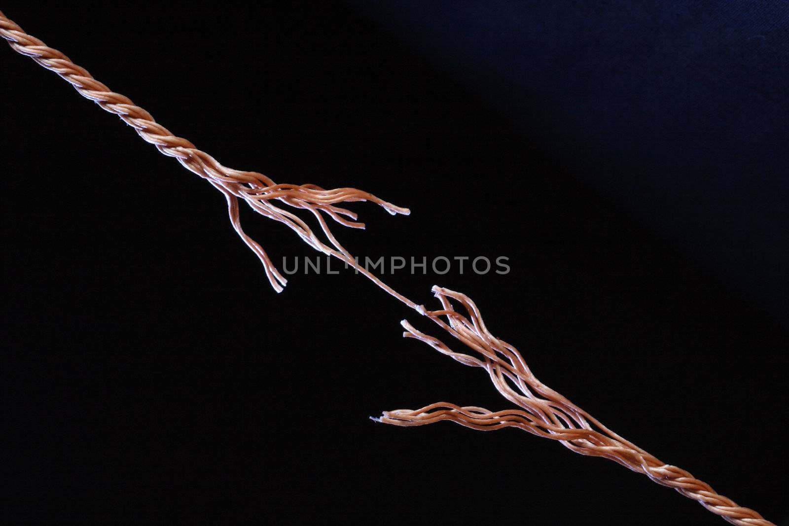 Frayed rope about to break isolated on black background with copy space