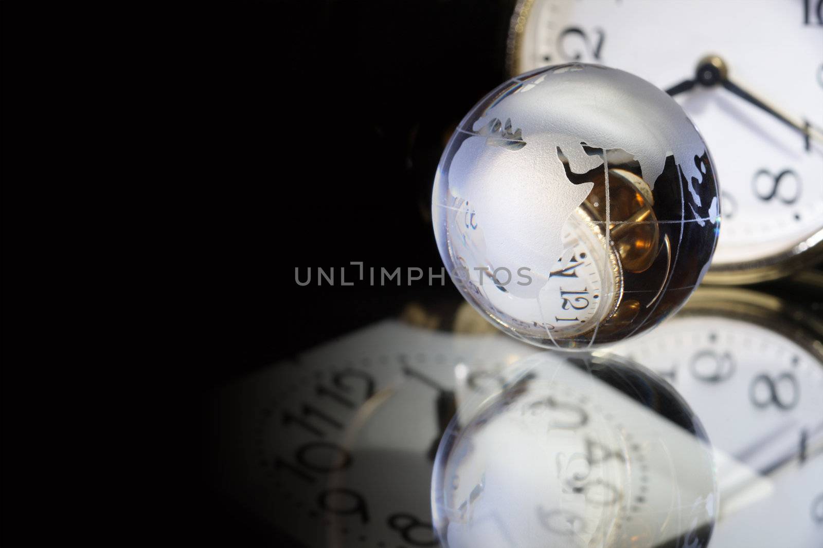 Glass globe on dark background with clock dials reverberation